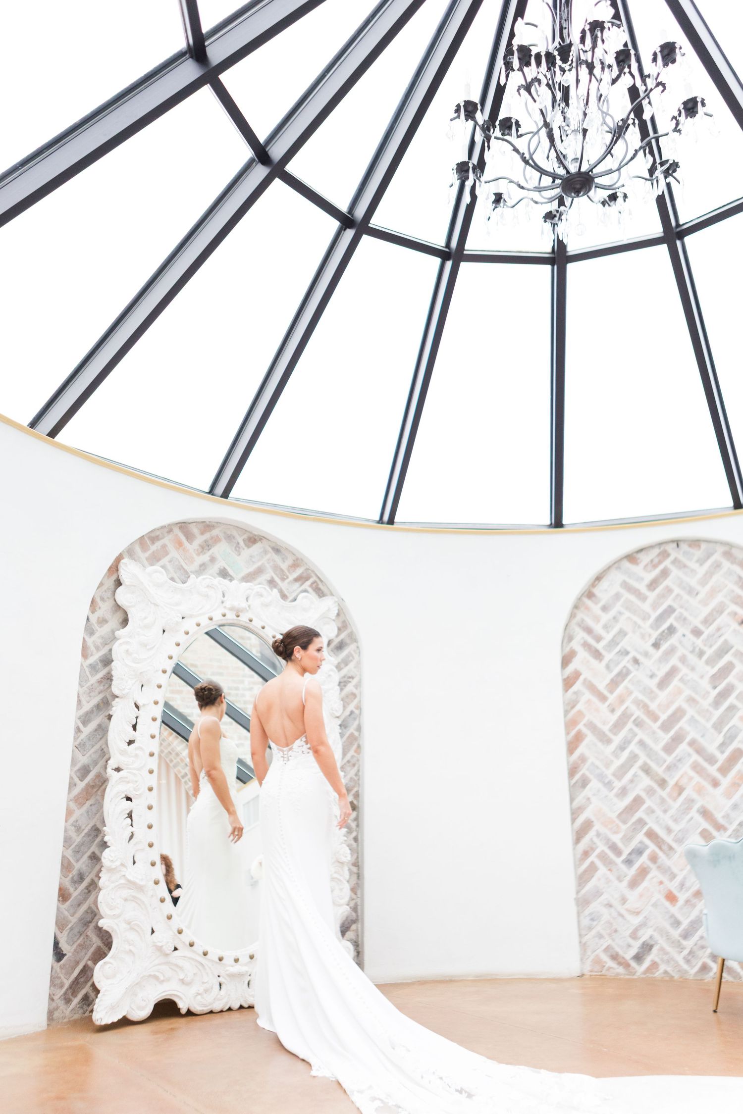 Wedding dress photographed under a skylight with herringbone pattern walls.