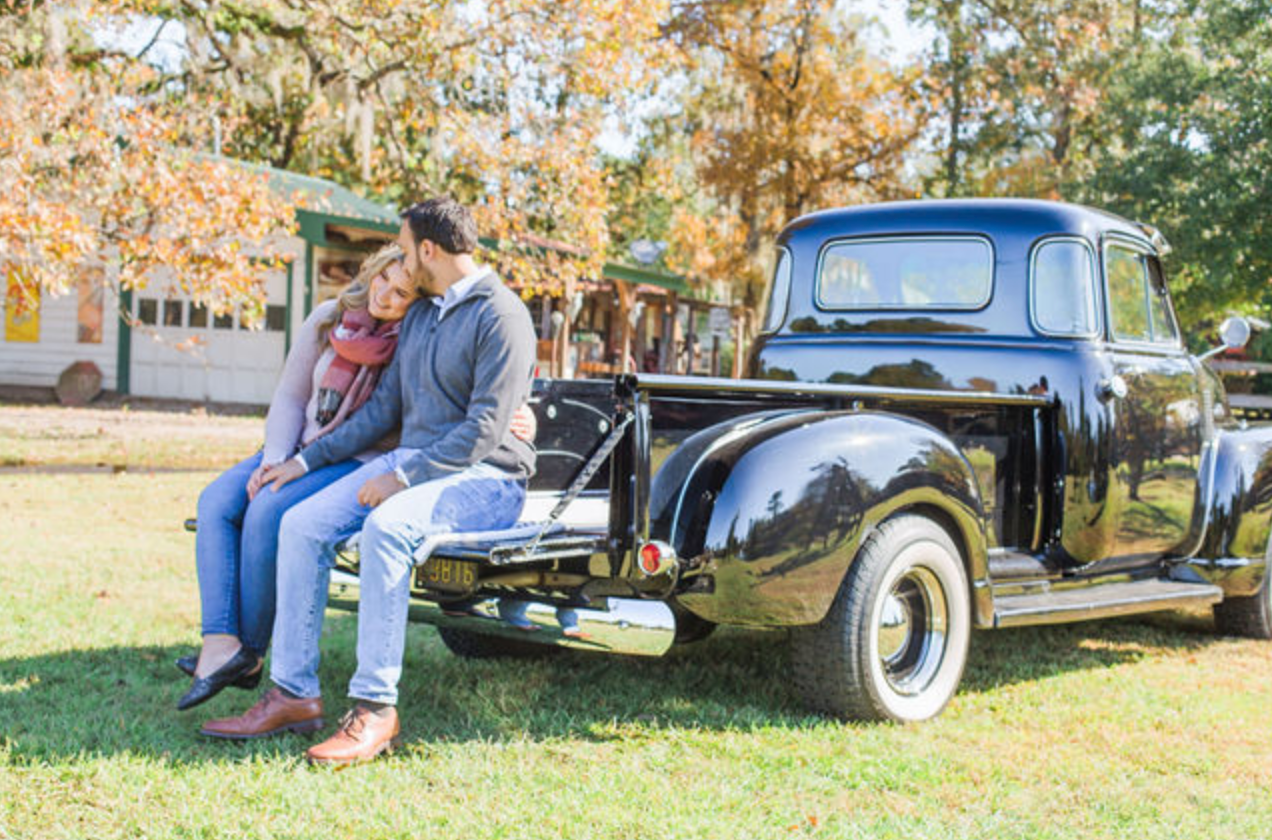 Vintage black car parked on grass during a fall photoshoot.