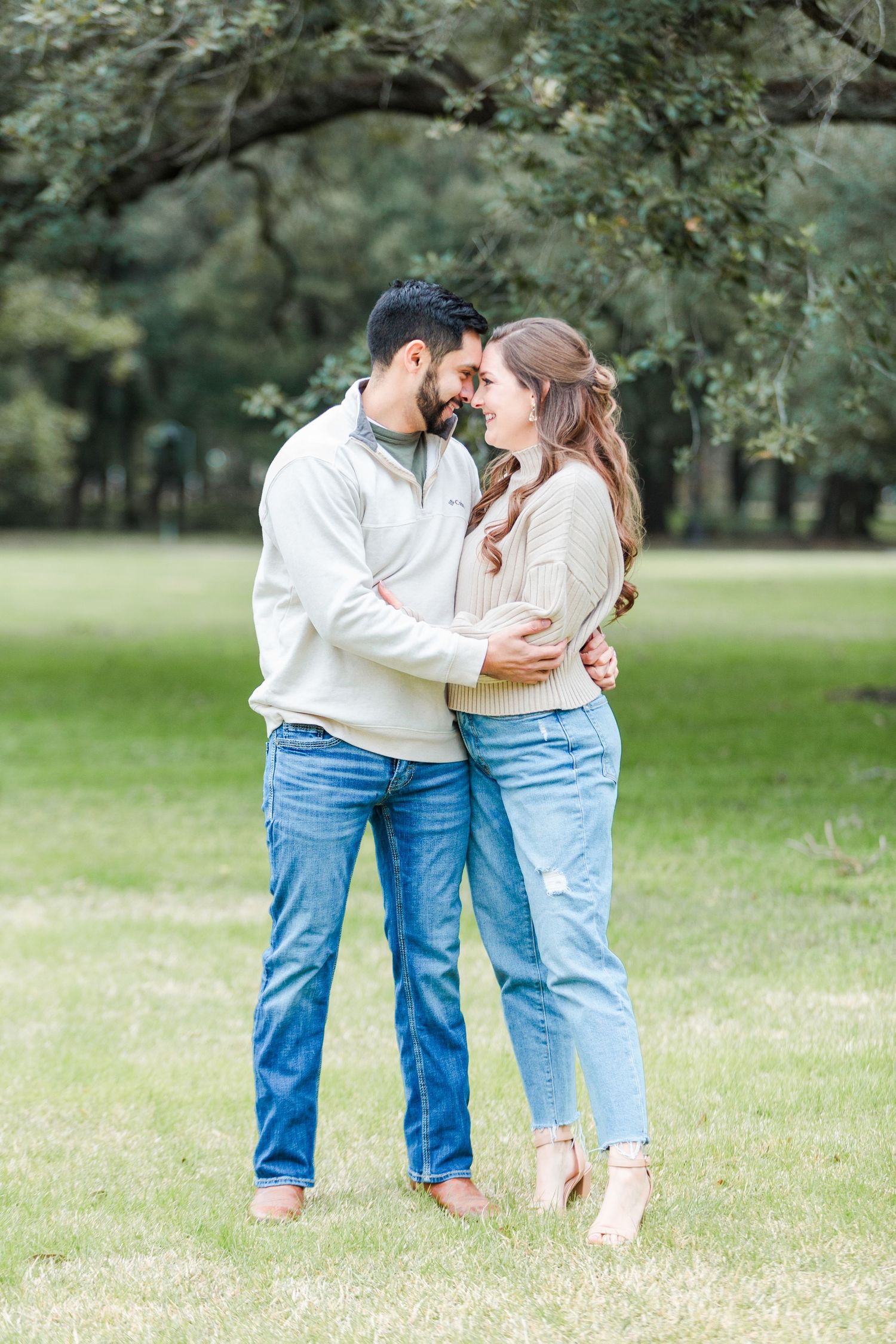 Candid couple moment captured in a sunny park with trees.