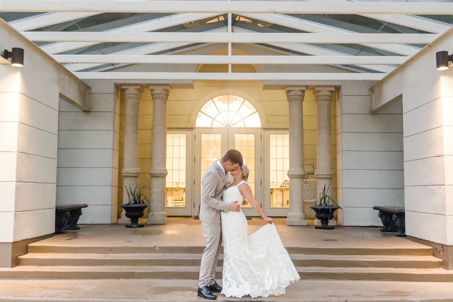 Wedding venue interior features white columns, exposed beams, and elegant architectural details.