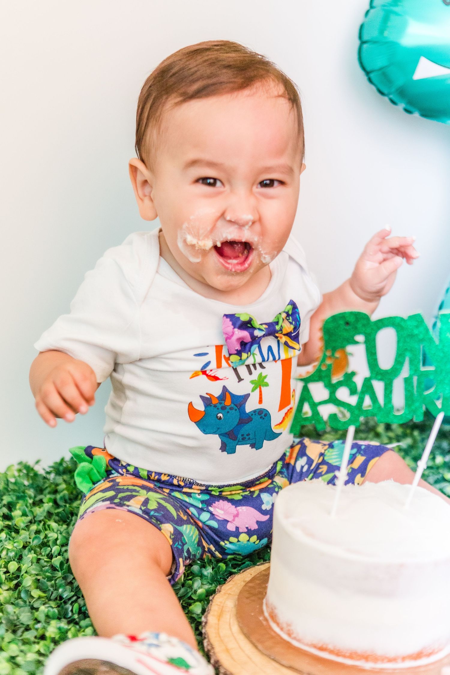 Festive birthday party scene with colorful cake and dinosaur-themed decorations.