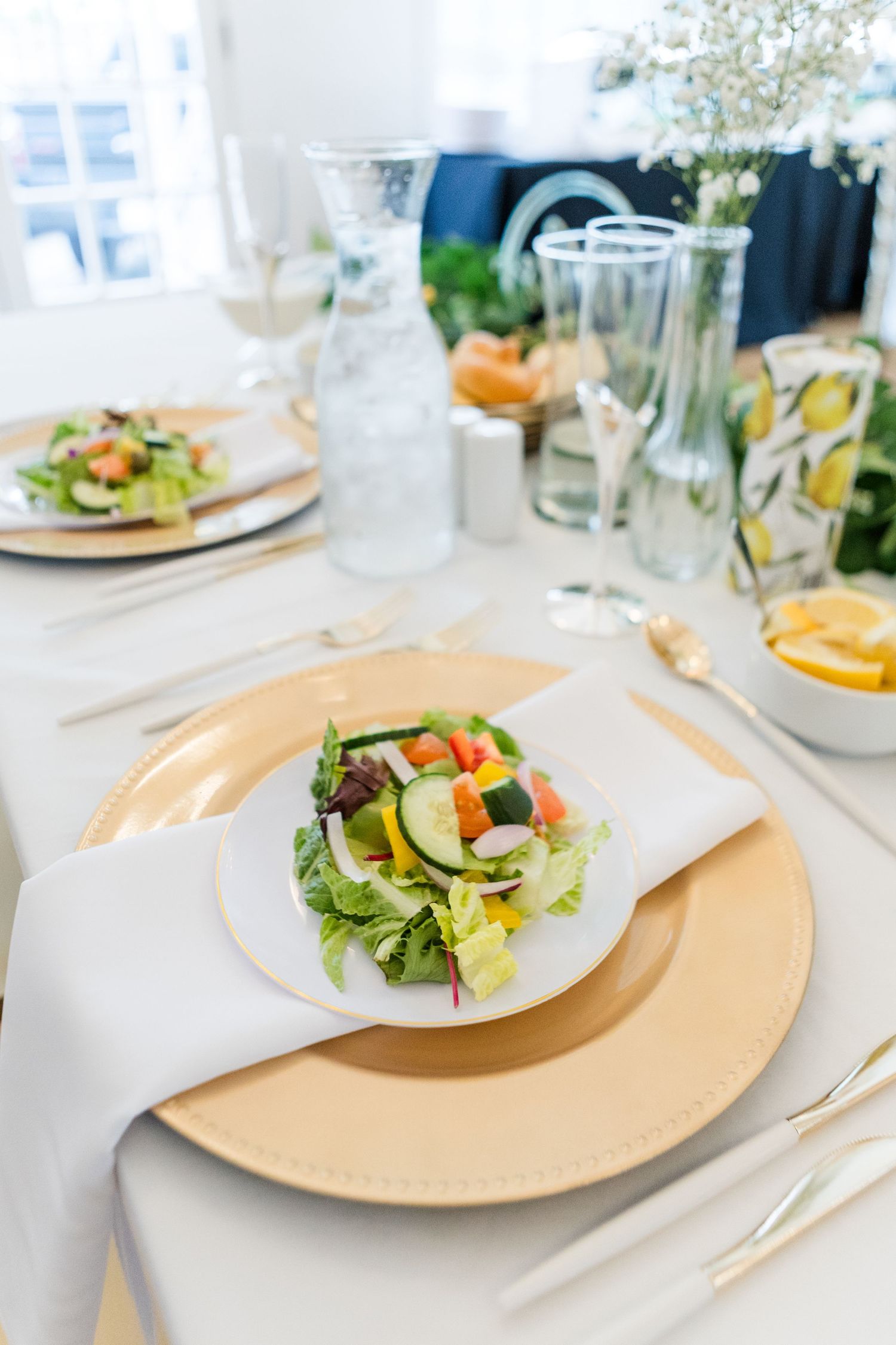 Elegant table setting with salad plates and glassware at wedding reception.