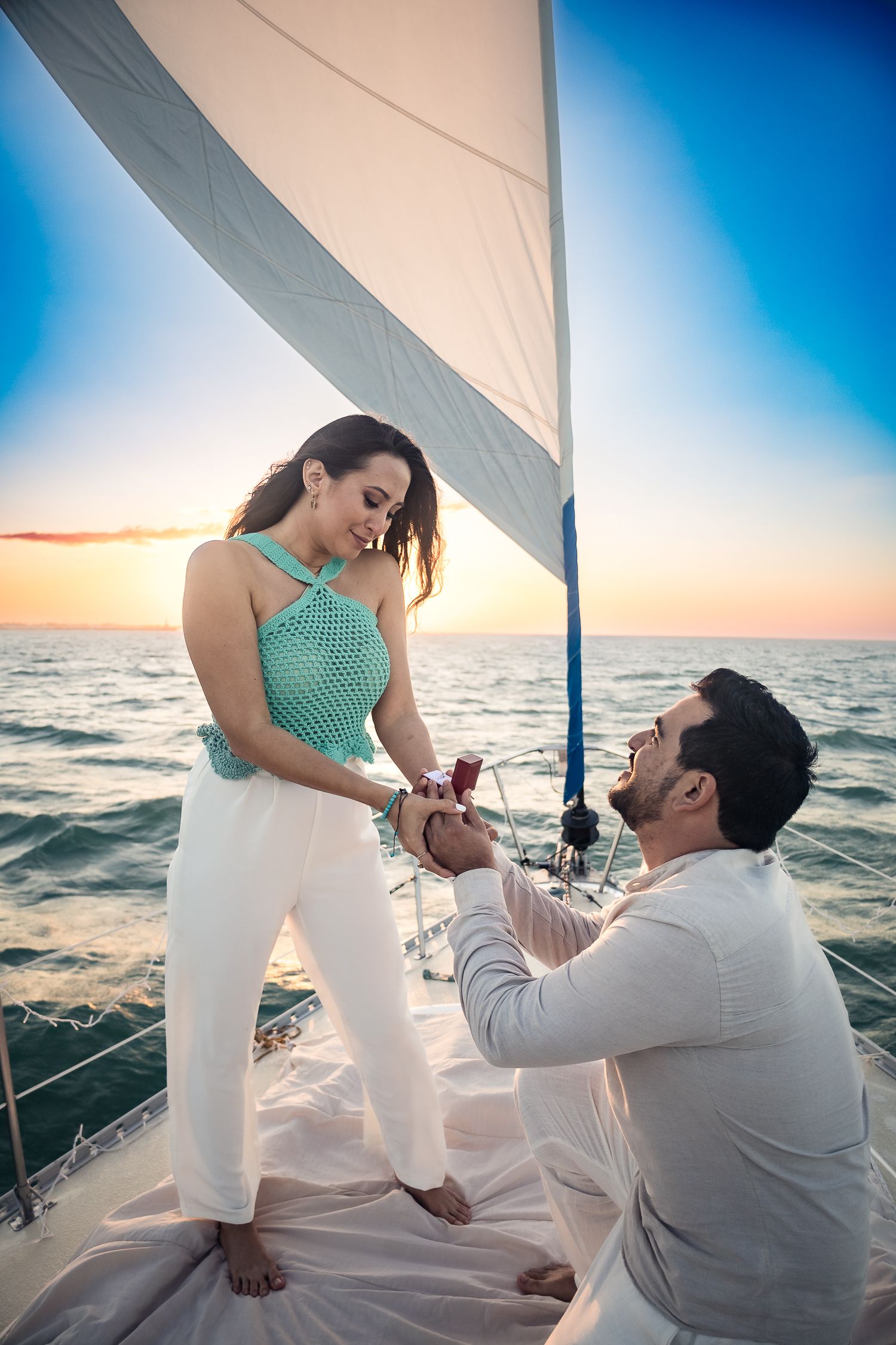 Propuesta de matrimonio en velero al atardecer durante sesión de compromiso en Yucatán