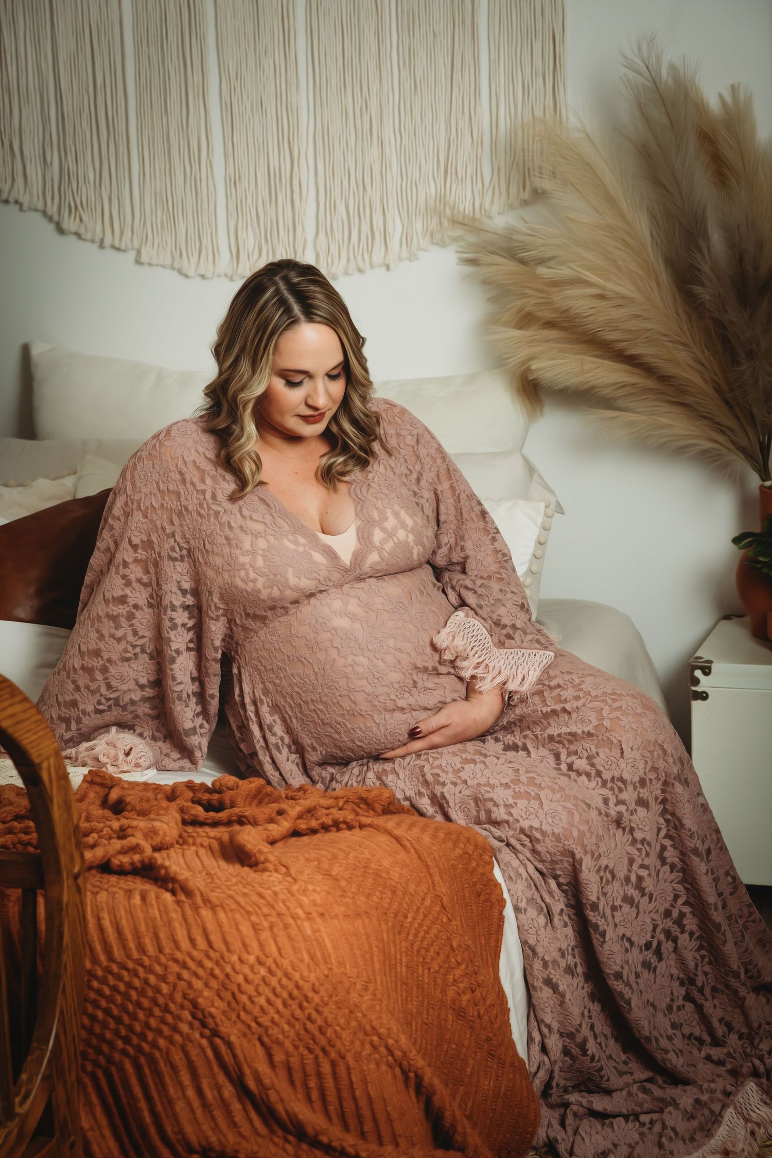 Pregnant woman sits on bed wearing lace gown for Maternity photo session with Tami Harris Photography in Worthington, Oh studio