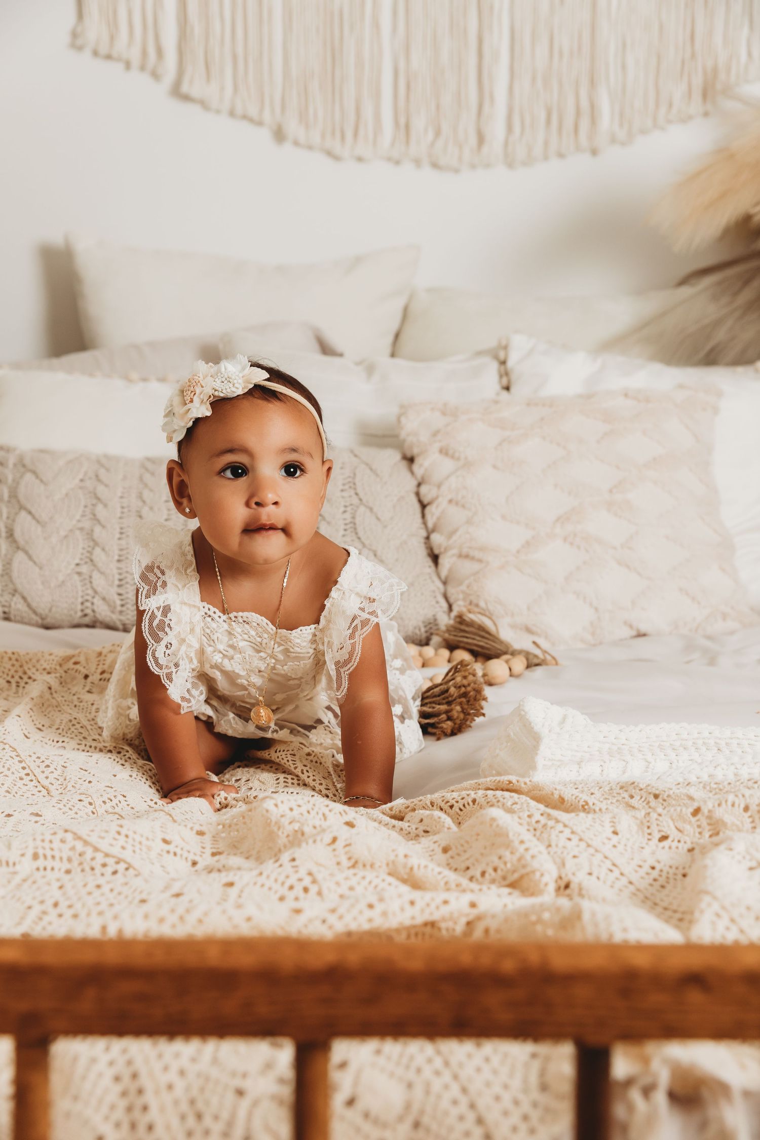 Baby girl crawls on bed in Tami Harris Photography studio in Worthington, Ohio for 1st birthday photoshoot
