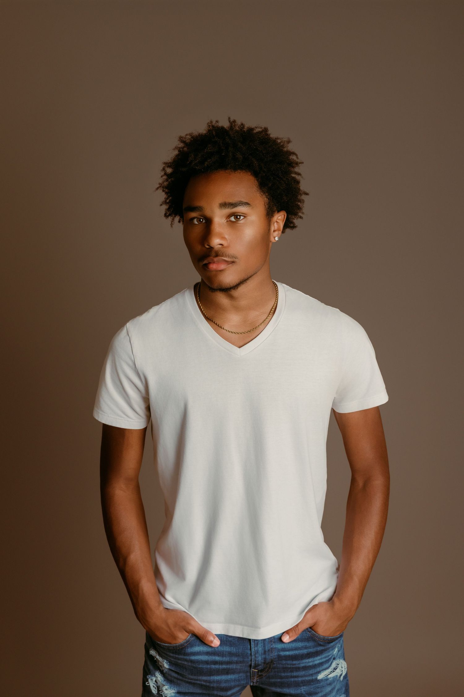 Heyman Talent model stands with hands in pockets during guy in-studio Senior photo session w/ Tami Harris Photography in Worthington, Ohio