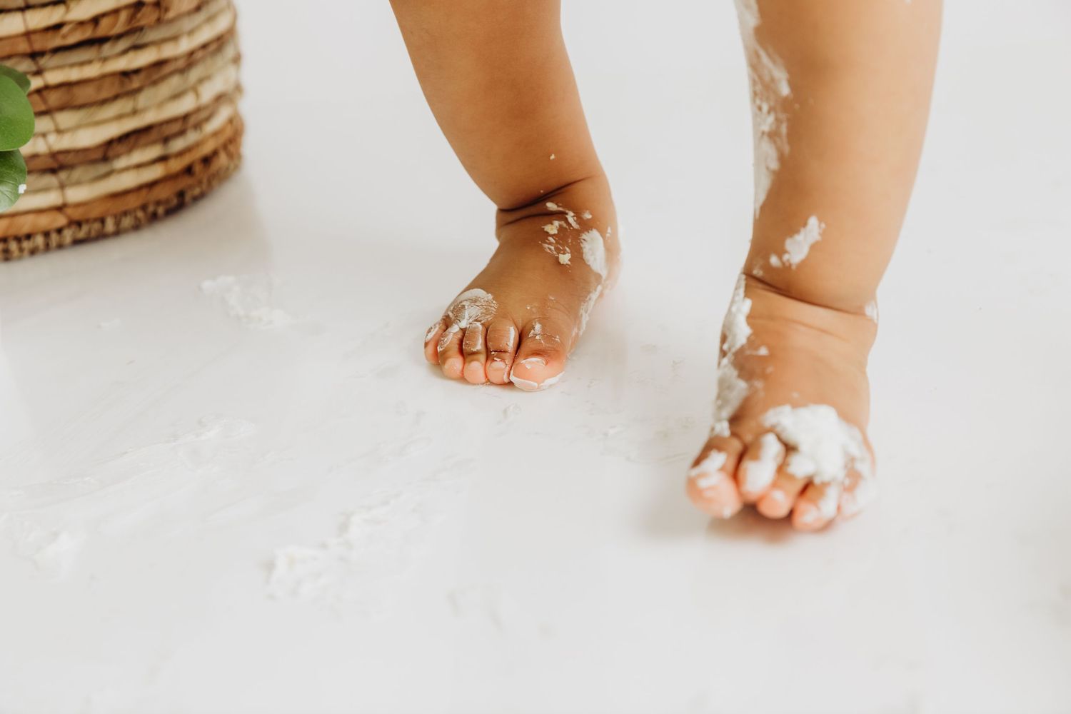 Close-up of baby feet covered in cake for 1st birthday cake smash photo with Tami Harris Photography in Worthington Ohio studio
