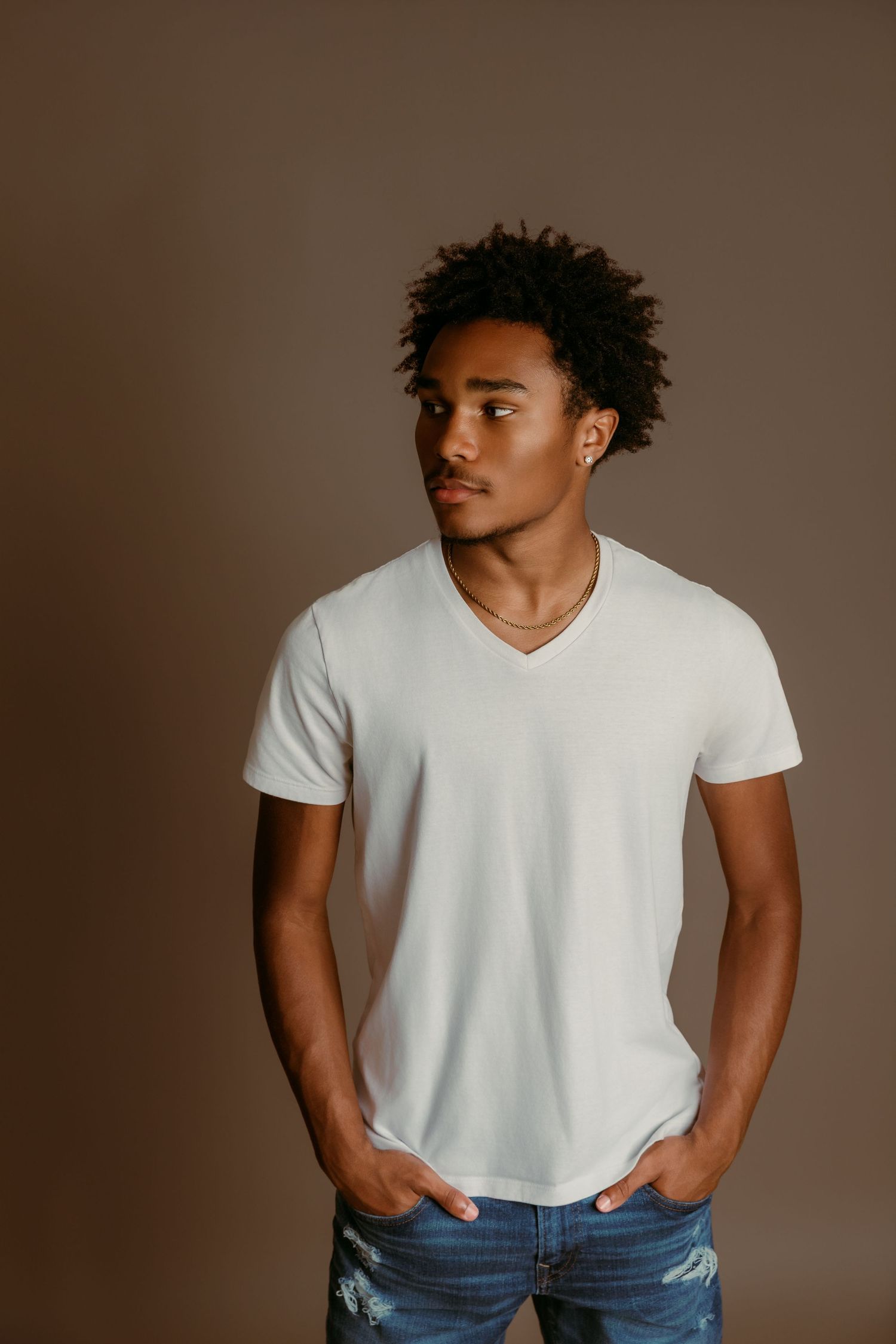 Senior Boy stands with hands in pockets in Tami Harris Photography studio
