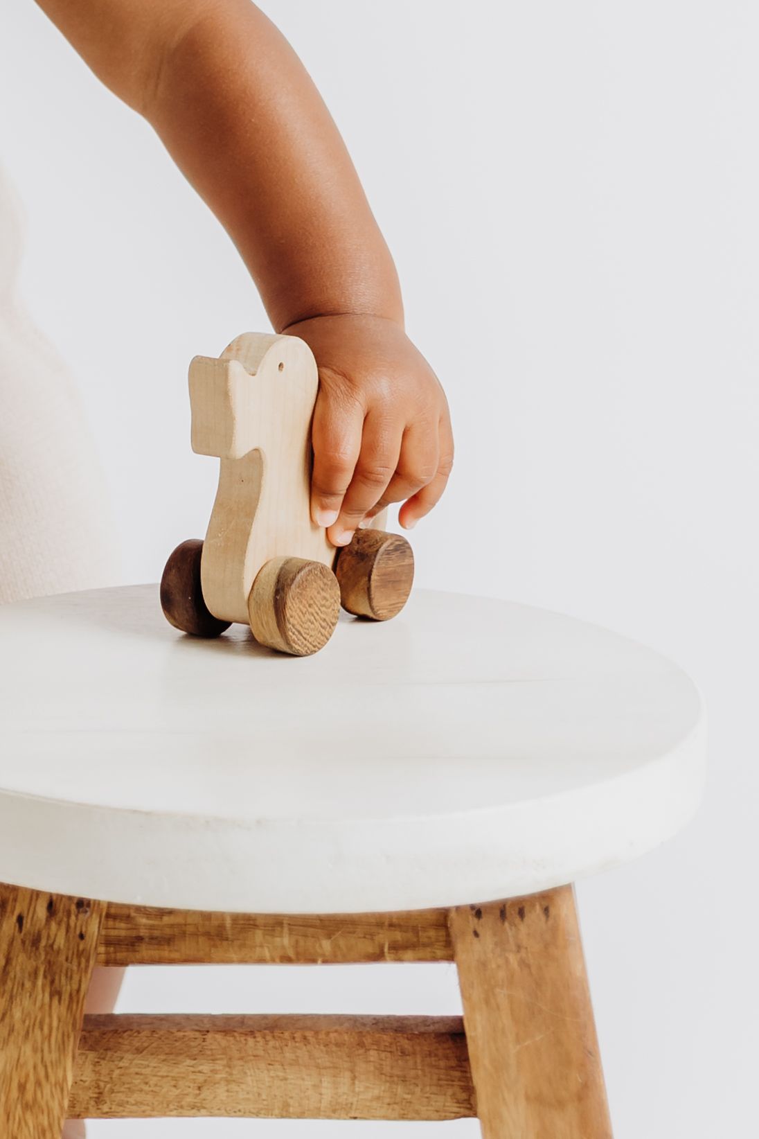 Close-up on child's hand playing with a wooden toy duck during milestone photo session with Tami Harris Photography in Columbus Ohio area