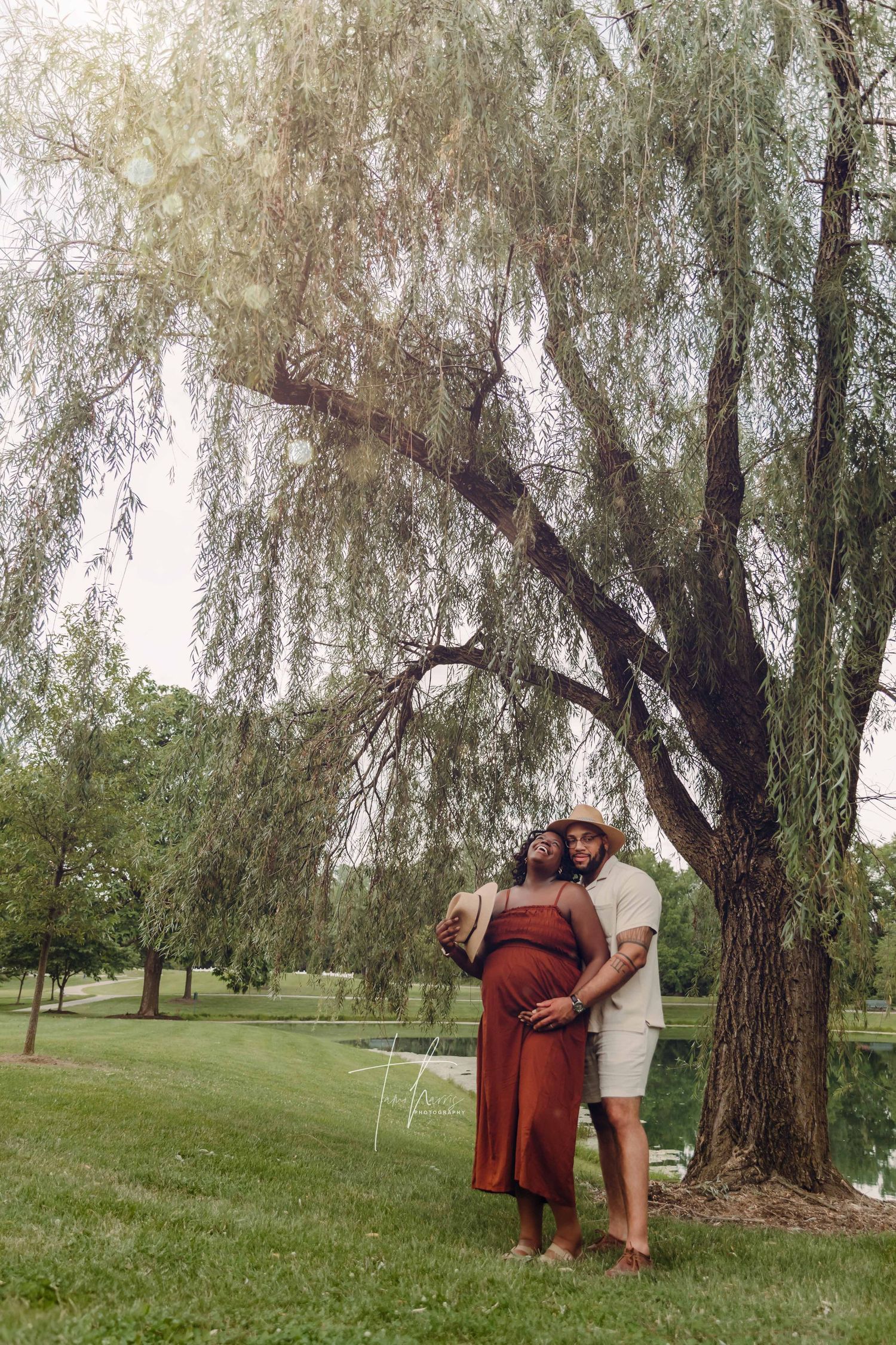 Couple embraces under a willow tree in Westerville Ohio at Everal Barn for outdoor Maternity portrait session with Tami Harris Photography