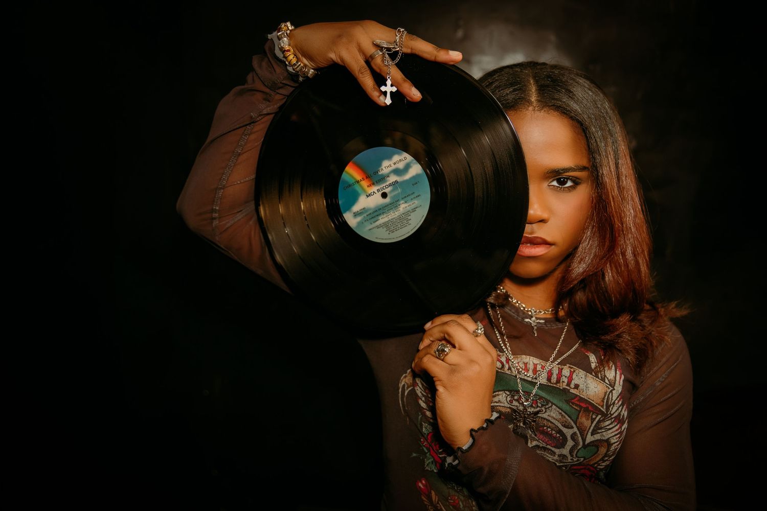 Senior portrait session at Used Kids Record store  - girl covers half of face with vinyl album