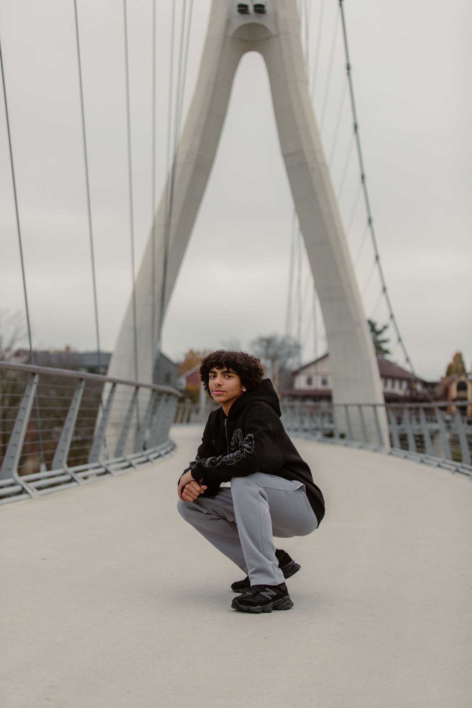 Senior boys crouched down in front of bridge at Bridgepark in Dublin, Ohio during Senior portrait session