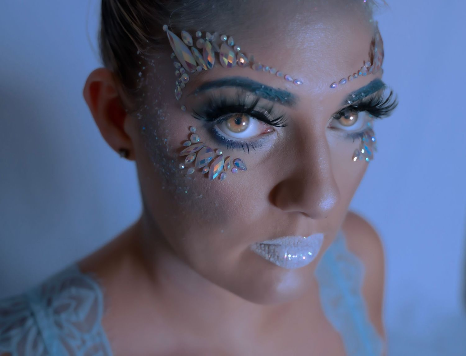 Close-up beauty shot with sparkly eye makeup and glitter details.