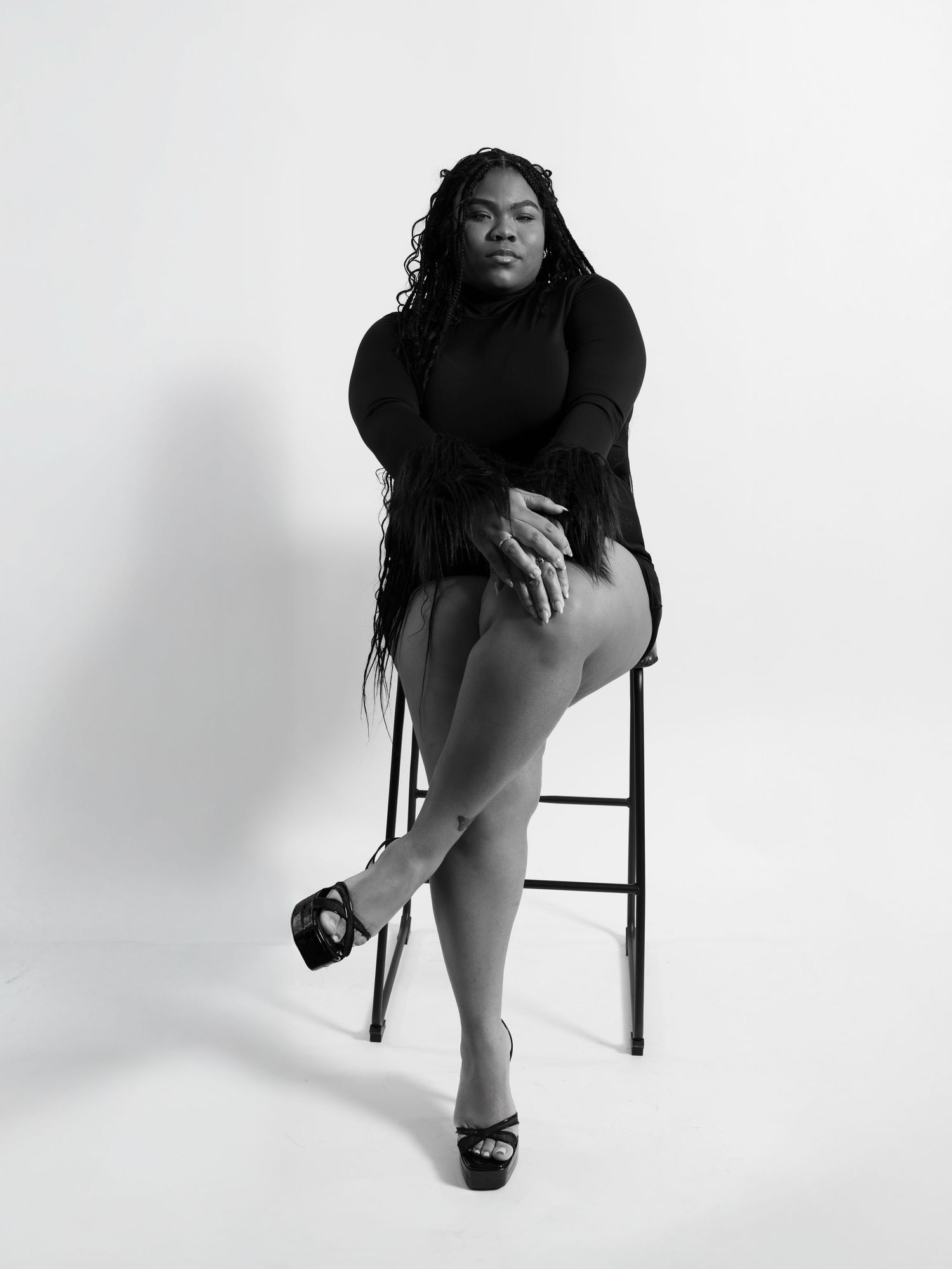 Artistic black and white portrait series showing person seated on chair in minimalist setting.