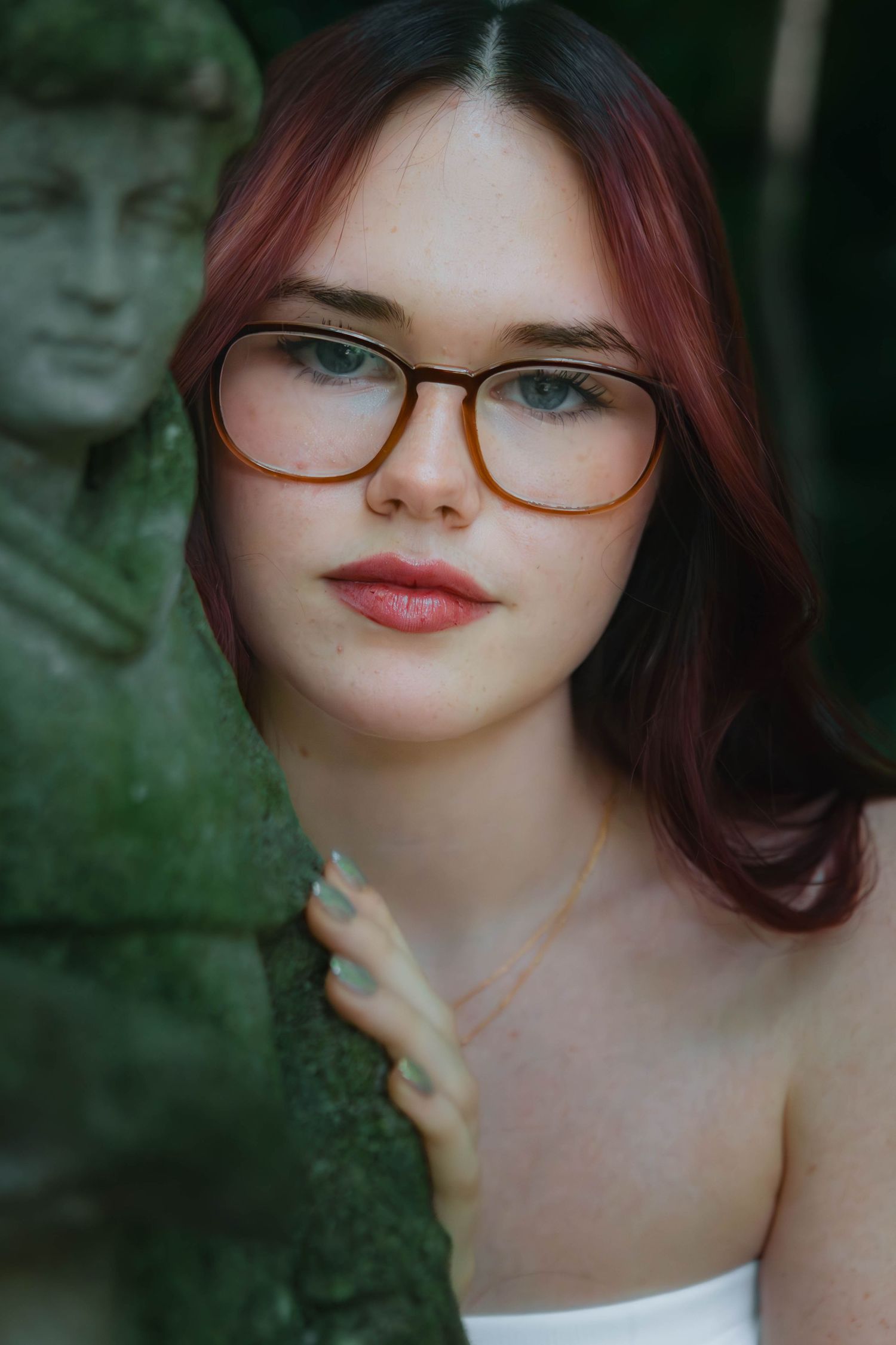 Person with red hair and glasses in an outdoor setting against a blurred green background in Youngstown, Ohio.