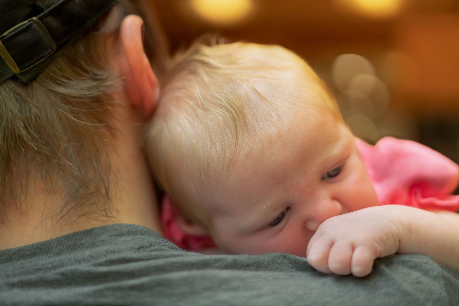 Infant sleeping peacefully with head resting on father showing tender and calm expression in Youngstown, Ohio.