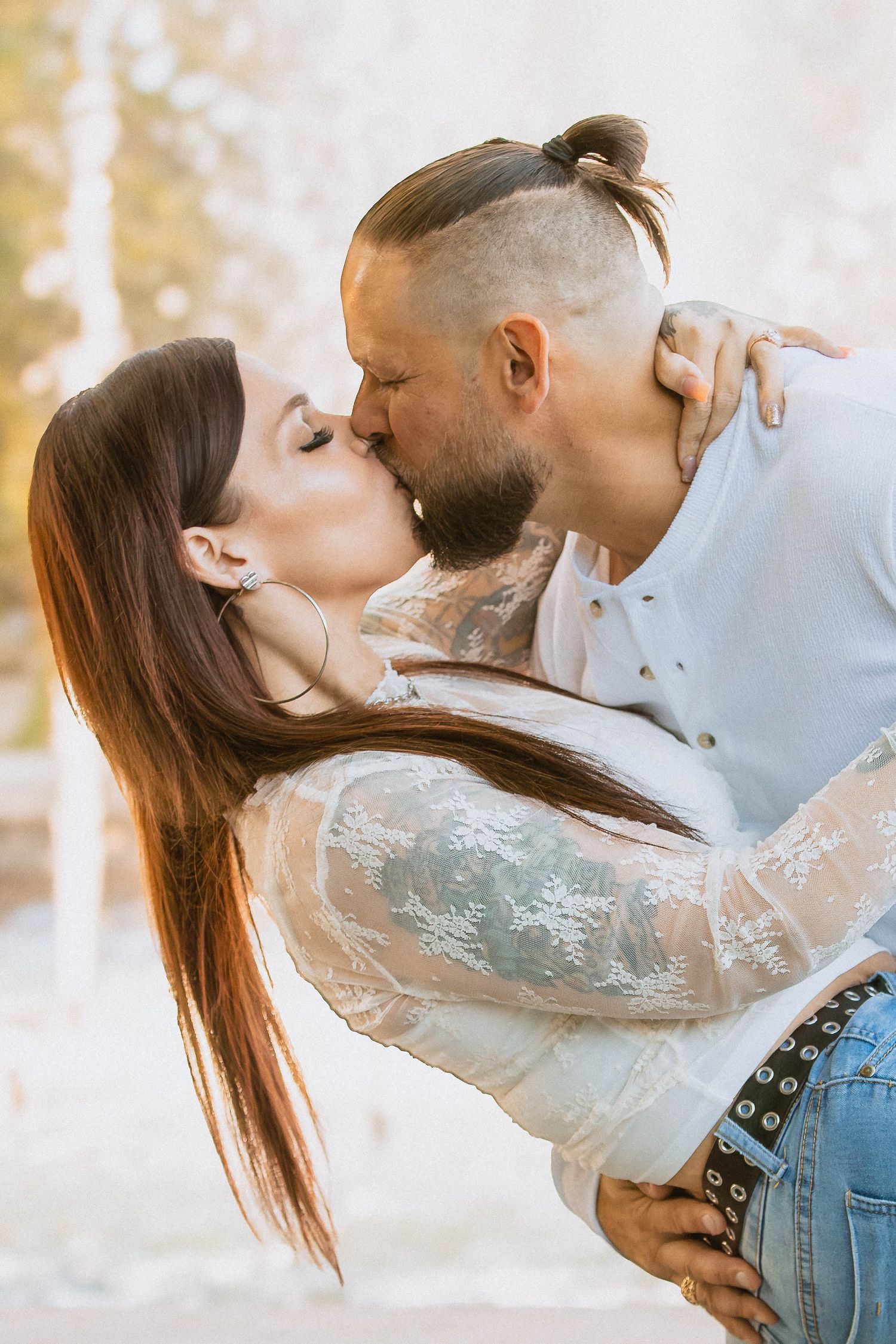 Romantic couple embracing and sharing tender kisses in soft sunlit outdoor setting showing artistic sequence in Youngstown, Ohio.