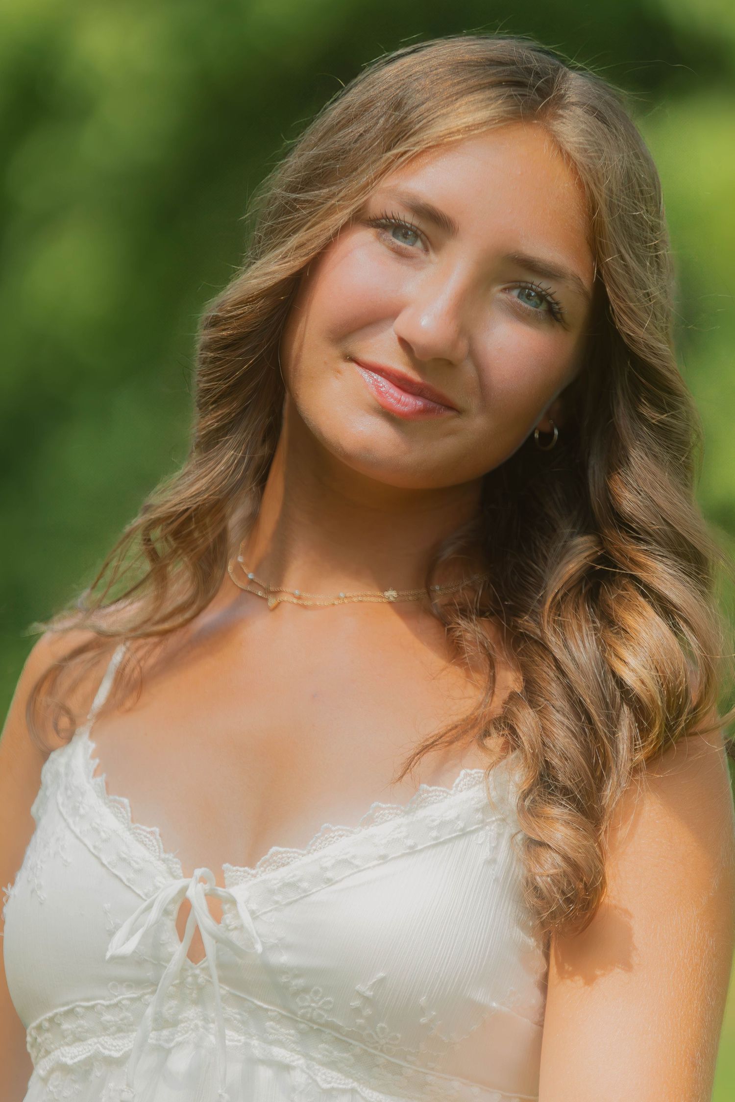 Natural outdoor portrait of someone wearing a white lace dress with soft lighting and greenery in the background in Youngstown, Ohio.
