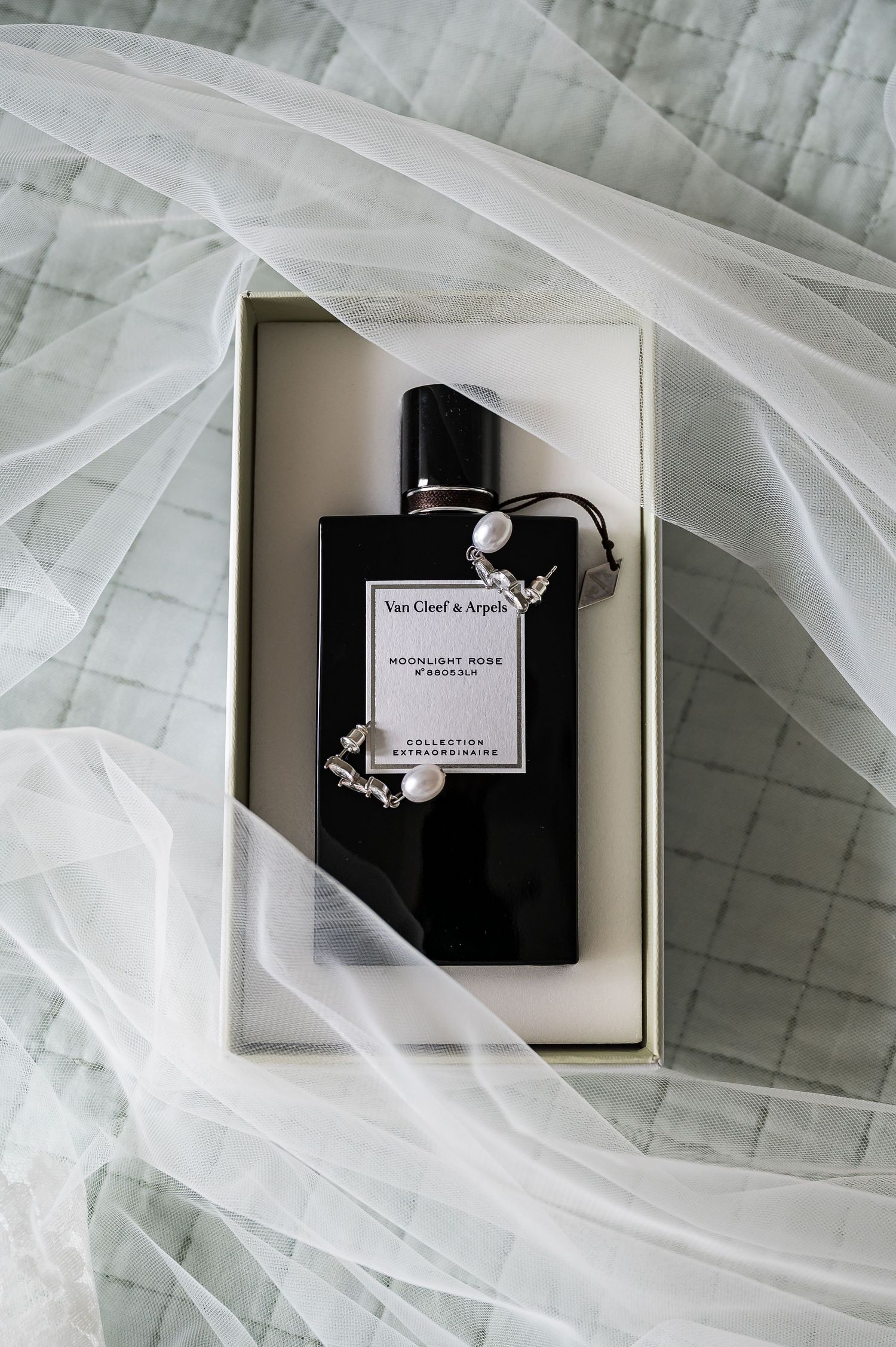 Van Cleef and Arpels Moonlight Rose perfume displayed in a box with a bridal veil.