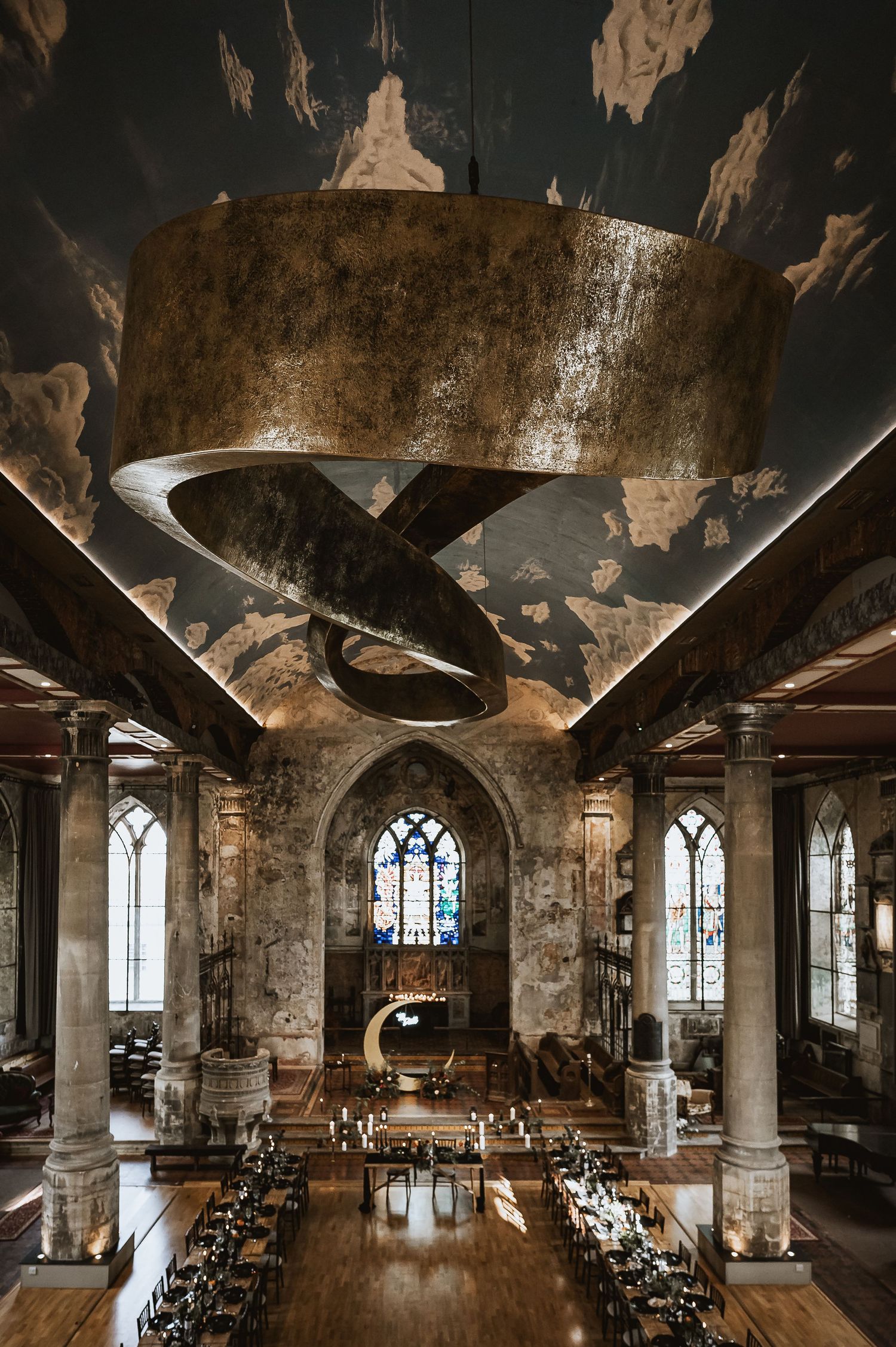 Stunning converted church wedding venue with dramatic spiral chandelier and Gothic windows.