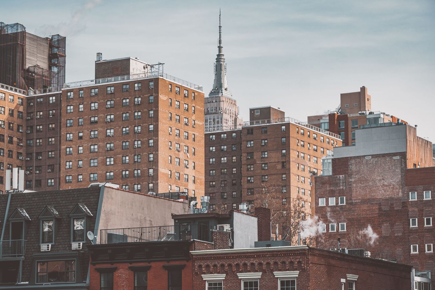 Urban skyline of brick apartment buildings and architectural details in muted tones.