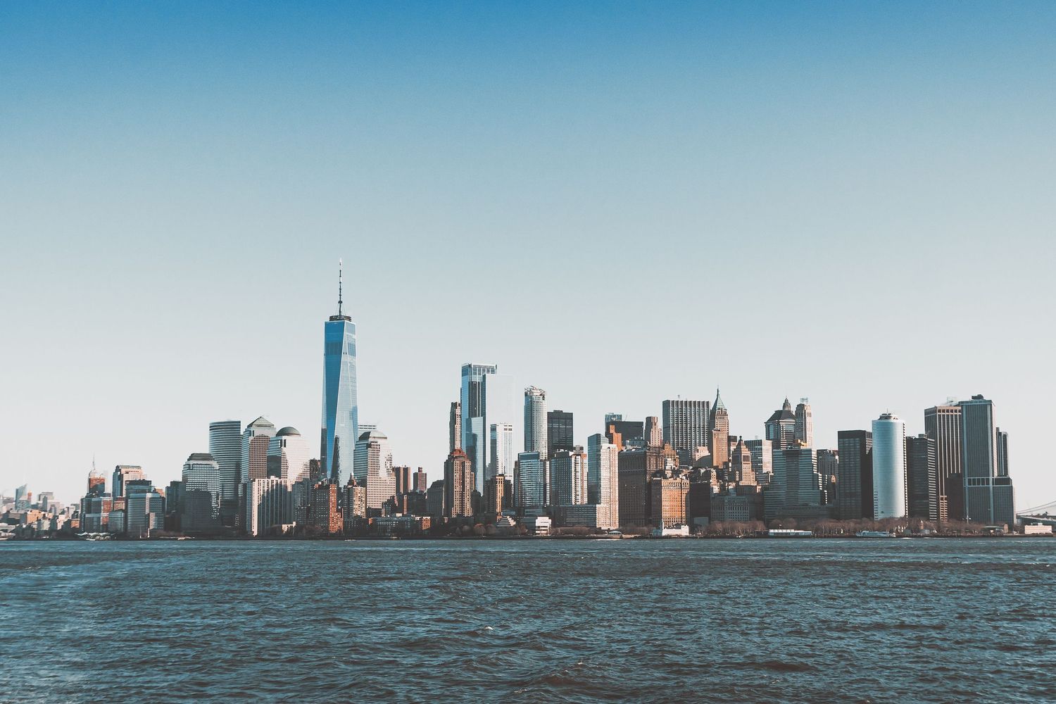 Manhattan skyline viewed from across water showing downtown skyscrapers including Freedom Tower.