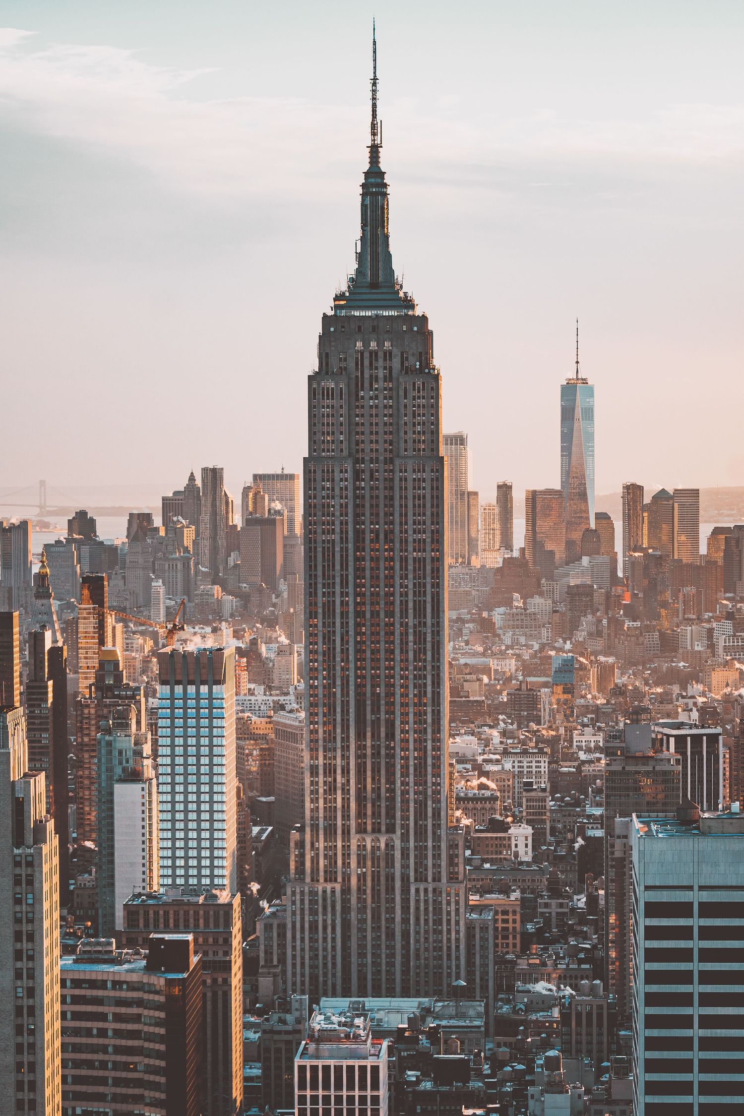 New York City skyline at sunset showcasing the Empire State Building and surrounding skyscrapers.
