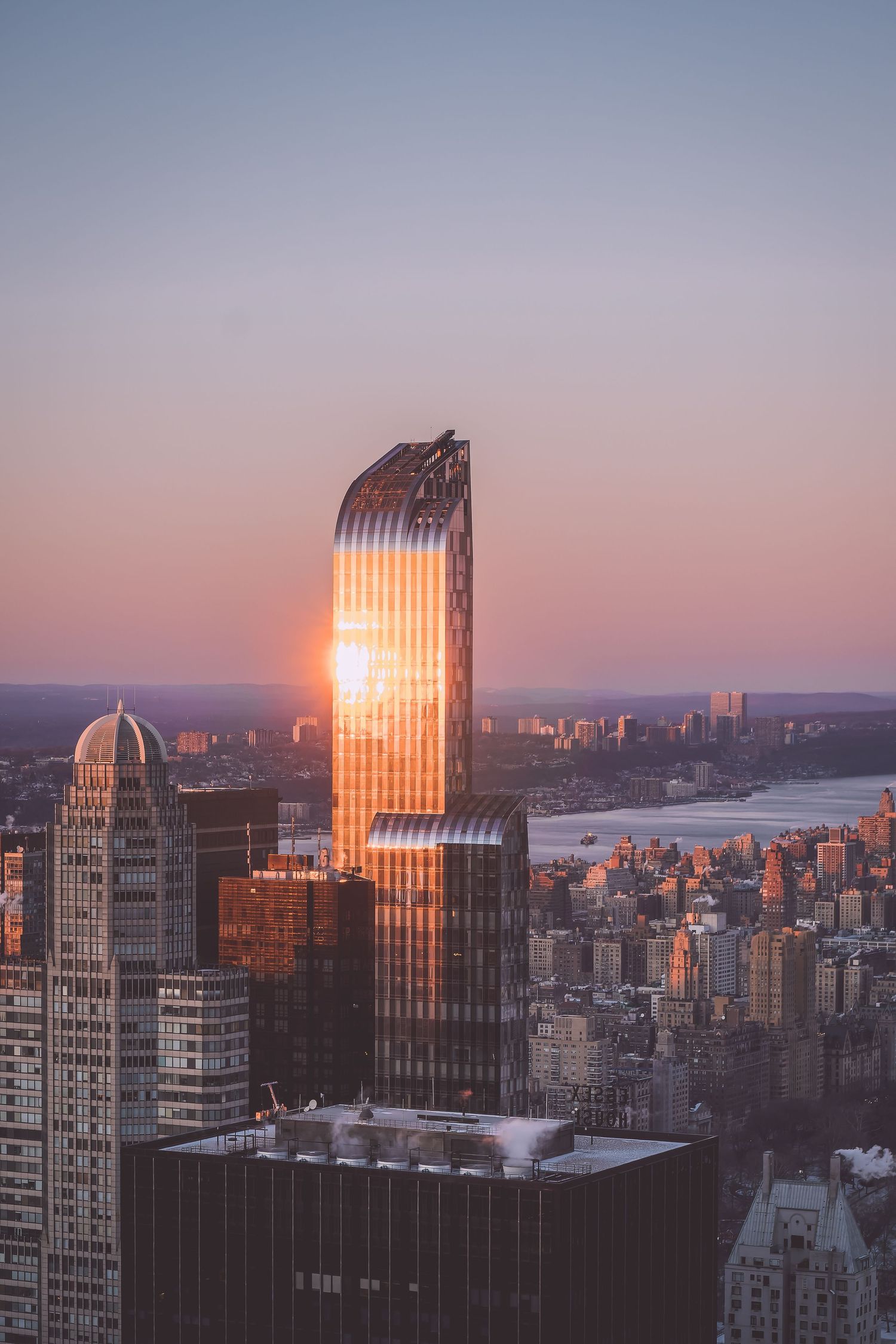 Modern glass skyscrapers reflecting golden sunlight during sunset in New-York.