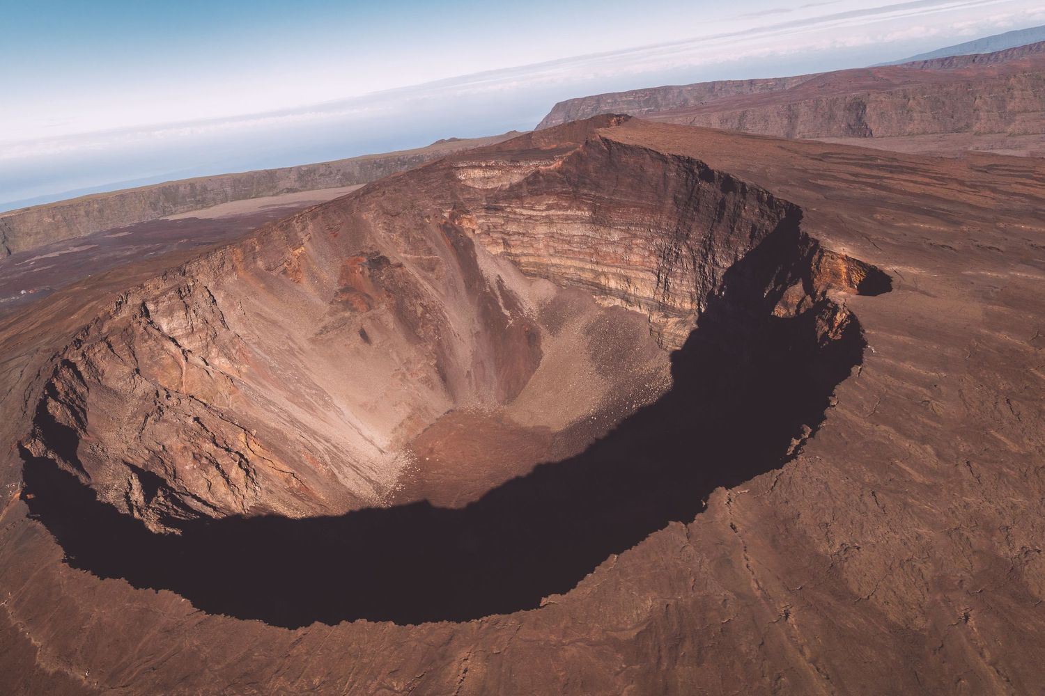 Aerial view of a massive volcanic crater in arid desert landscape in Reunion island.