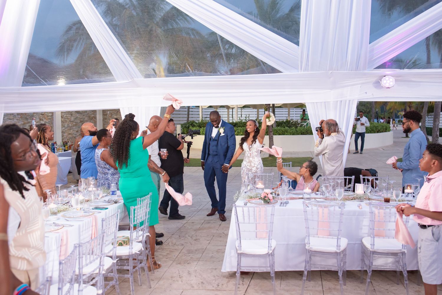 Wedding reception venue with white chairs and elegant draping.