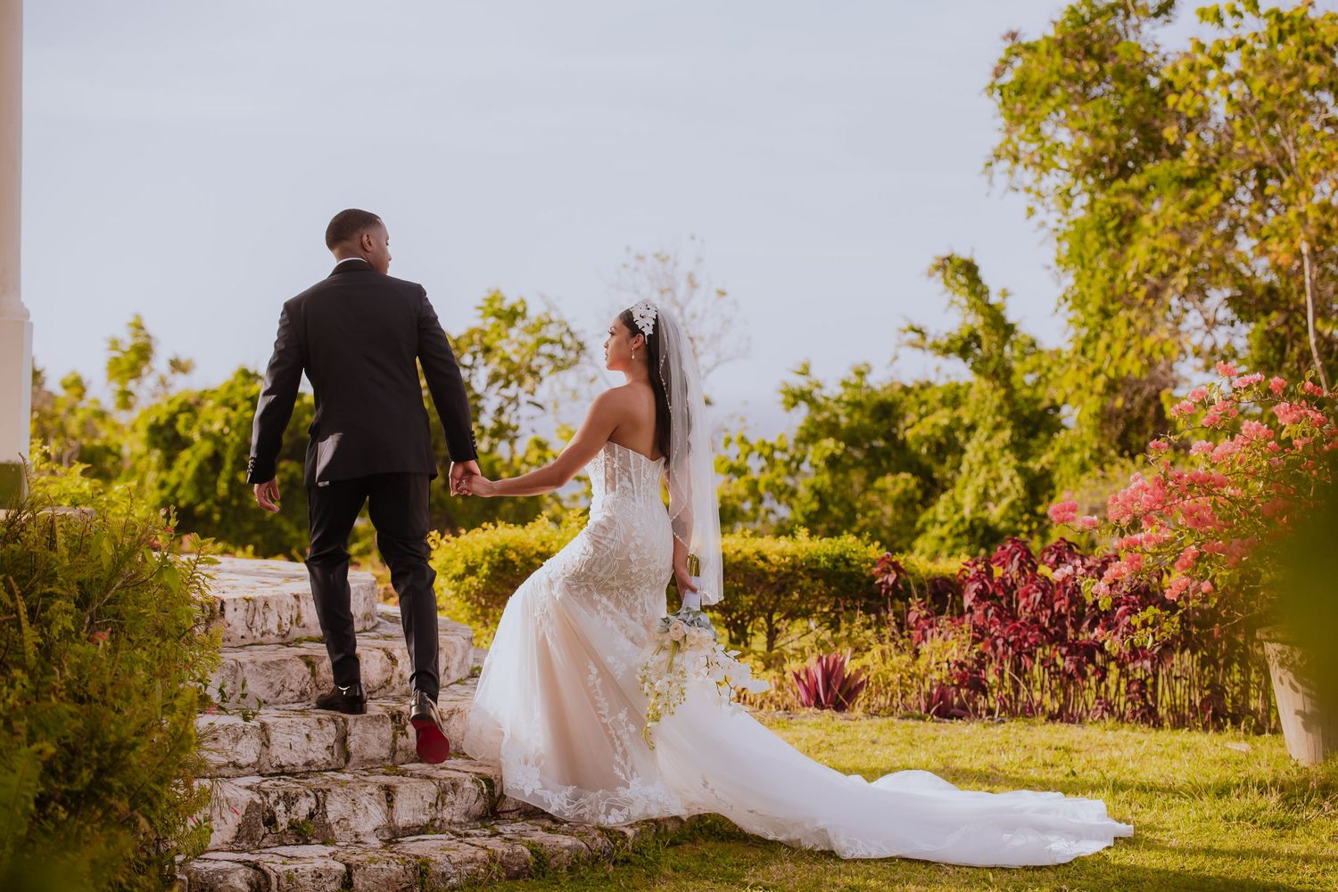 Wedding couple shares intimate moment in lush garden setting during golden hour.
