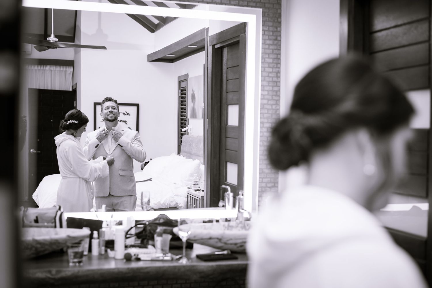 Black and white photograph of wedding day preparations in an elegant interior setting.