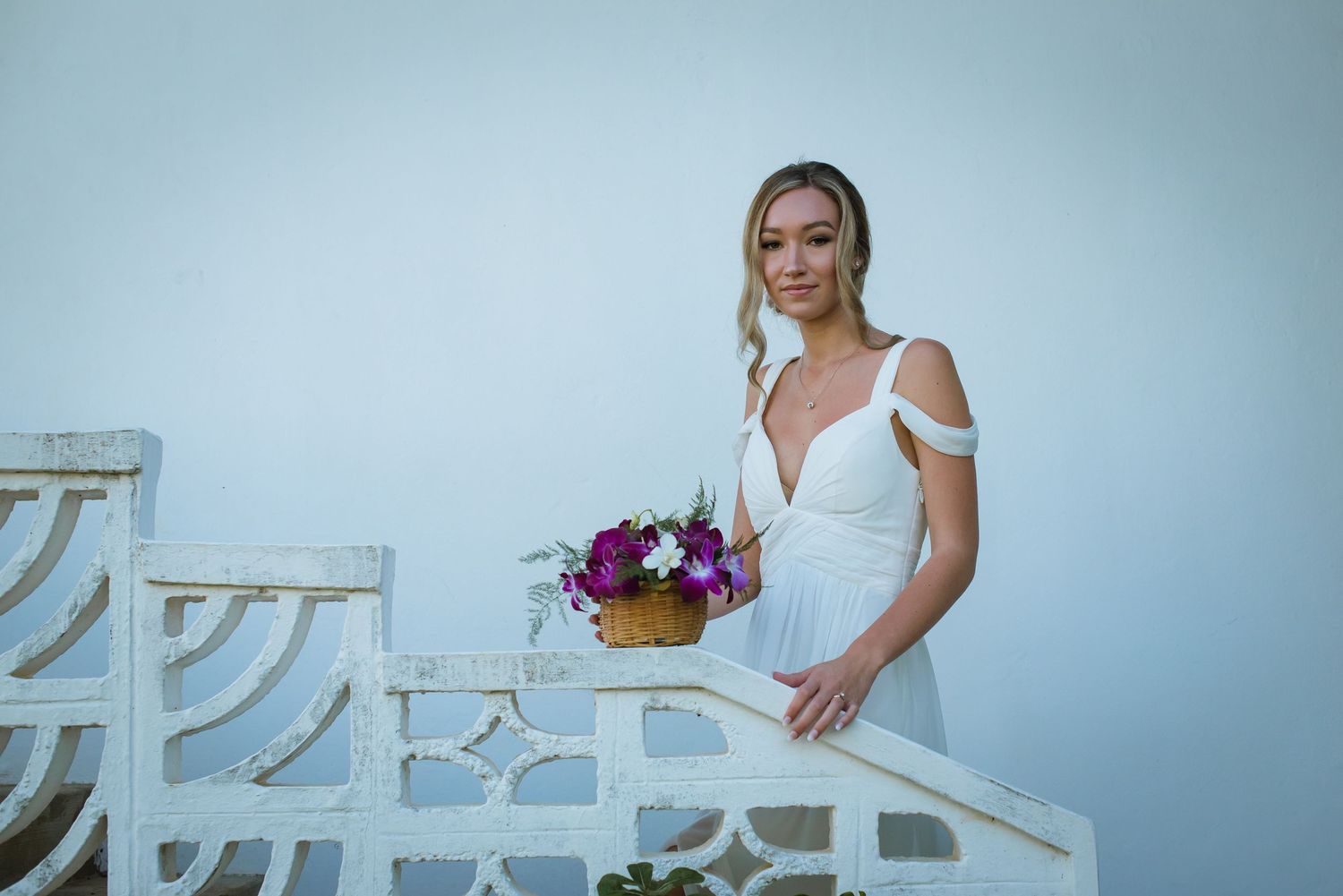 Elegant bridal portraits taken against a light blue background with white furniture.