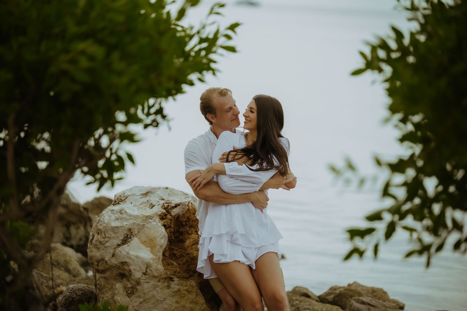 Intimate couple photography session among lush tropical foliage by the ocean.