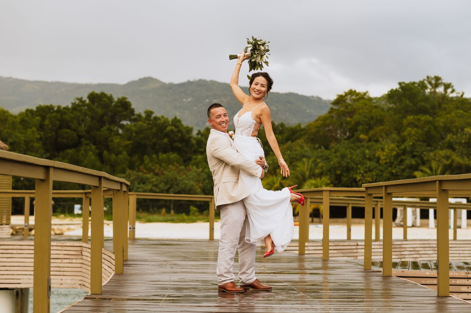 Romantic photoshoot on a wooden boardwalk with overwater bungalows and tropical scenery.