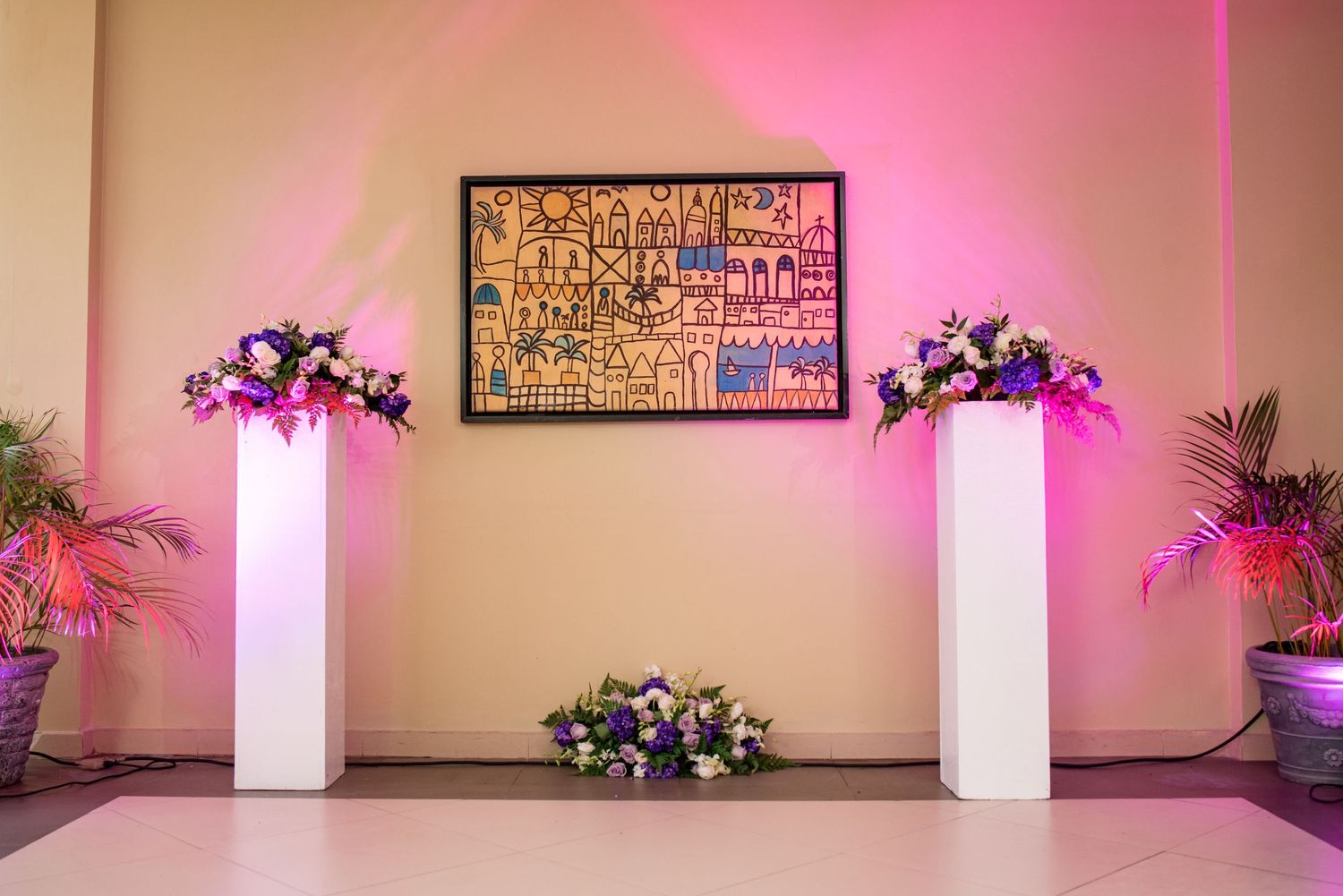 Modern event space decorated with pink lighting and abstract wall art.
