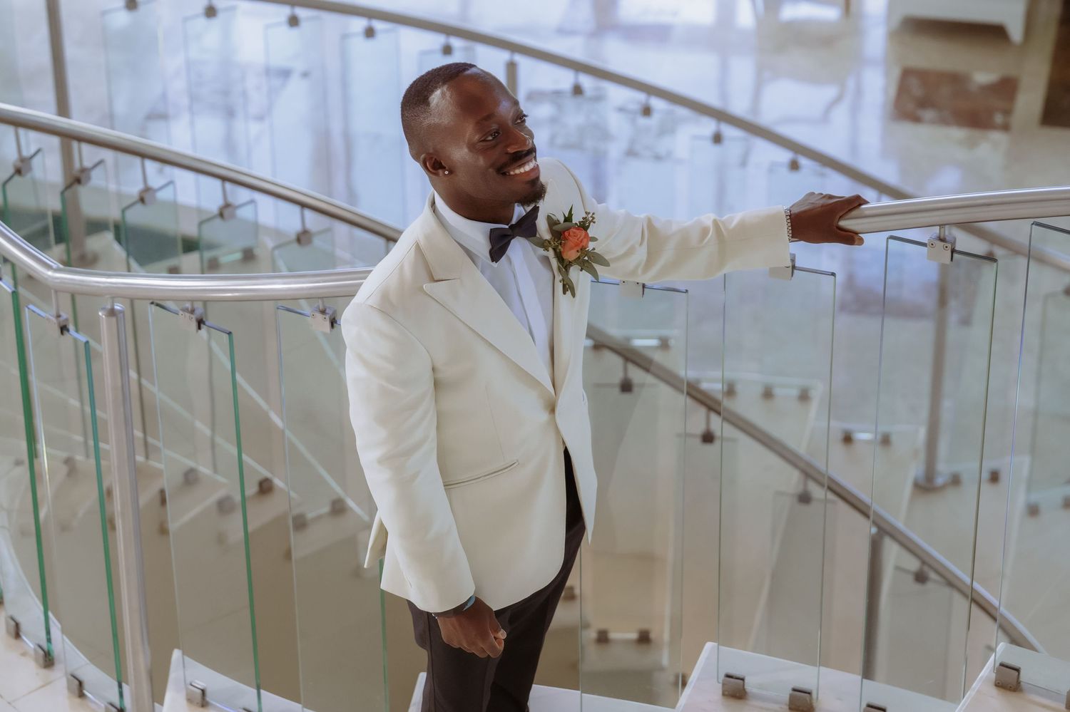 Celebratory moment on a modern staircase with glass railings.