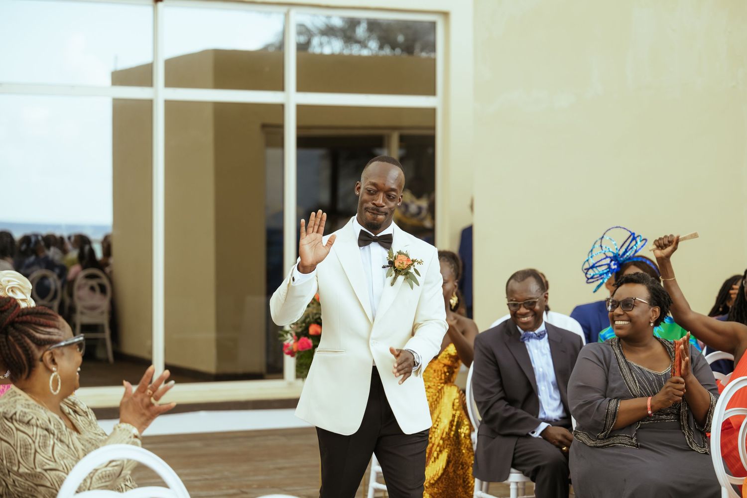 Wedding guests celebrate during an indoor ceremony with joyful expressions.