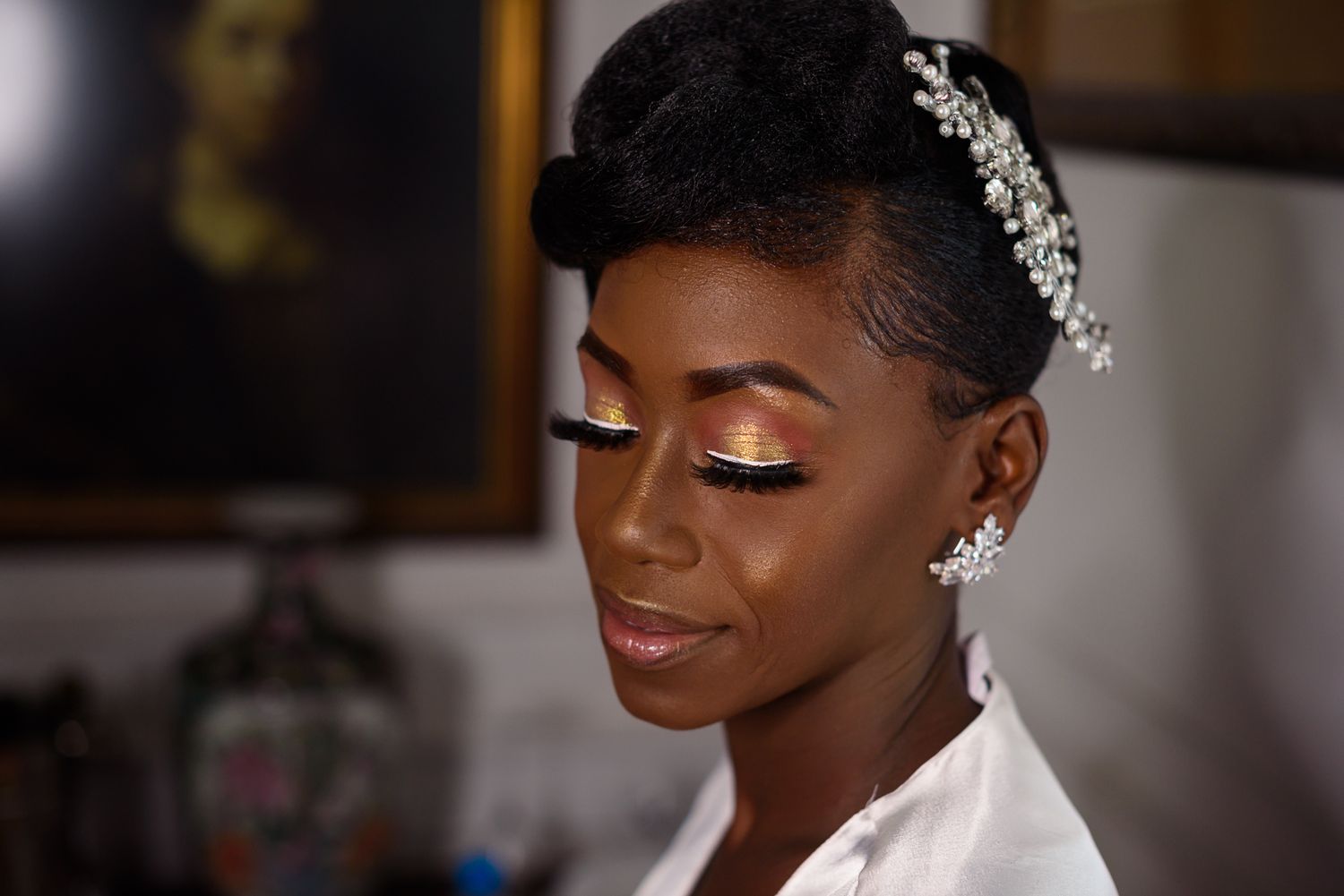 Close-up of bridal makeup featuring shimmering eyeshadow and a crystal hair accessory.