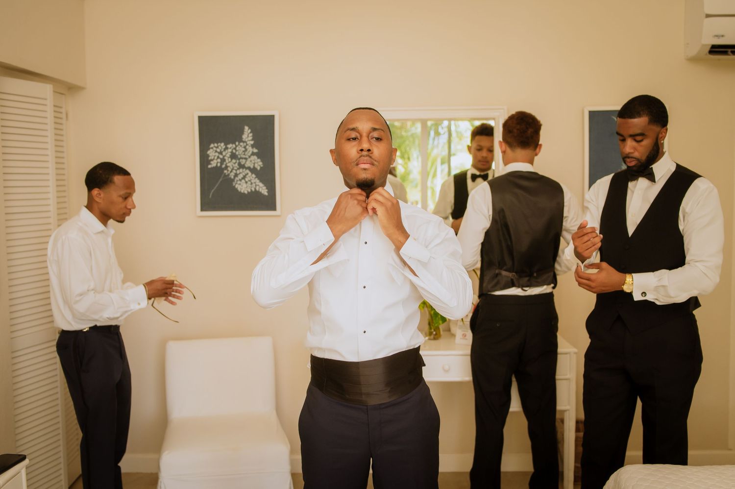 Wedding party members gather in preparation room before ceremony.