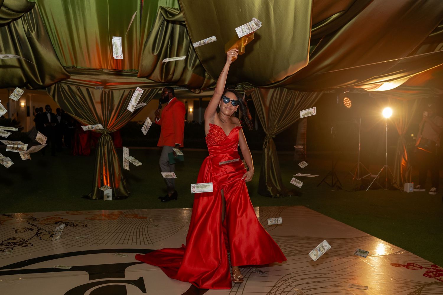 Wedding reception dance floor with guests celebrating and money being thrown in the air.