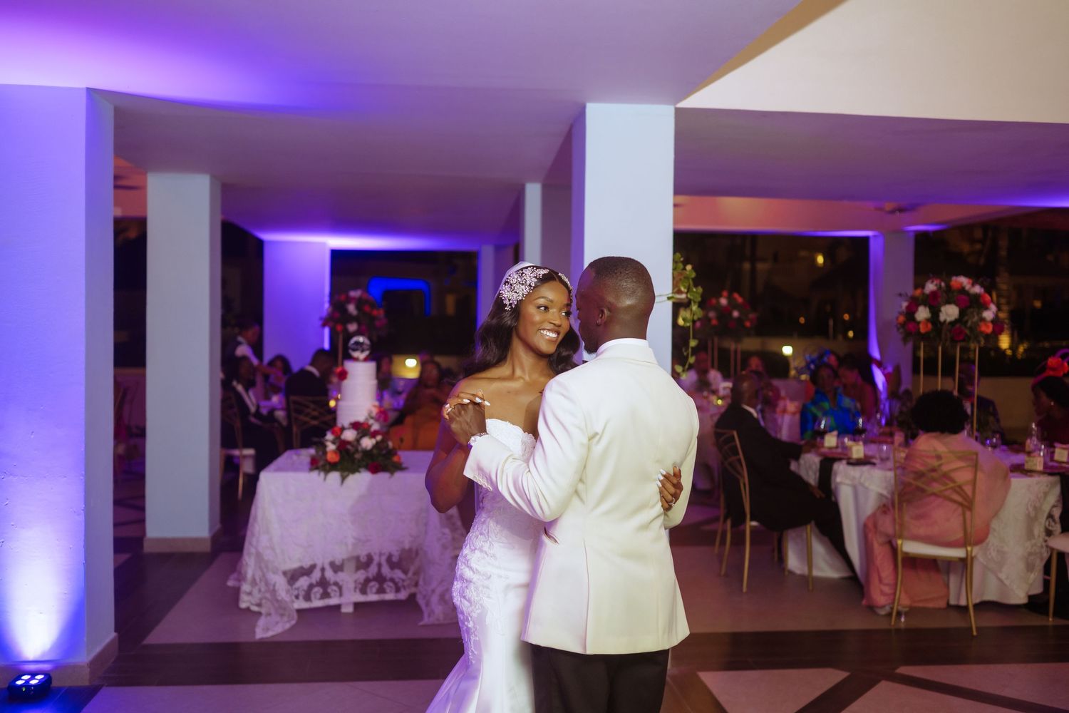 First dance moment at wedding reception with purple ambient lighting.