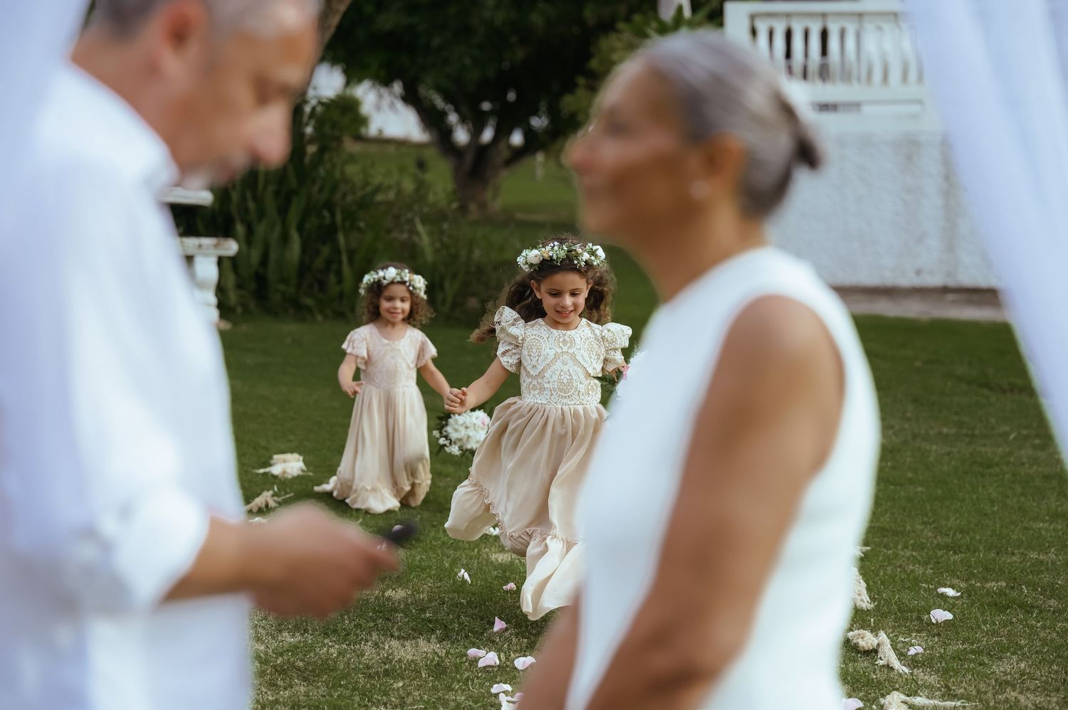 Wedding celebration scene with guests and decorations in an outdoor garden setting.