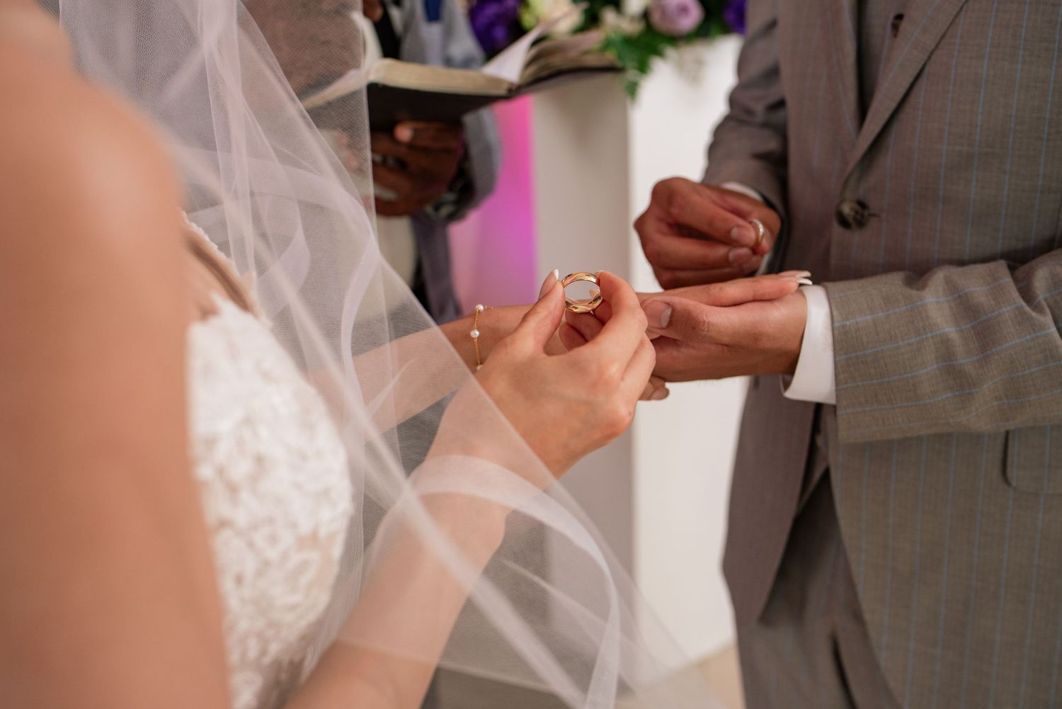Close-up shots of wedding rings being exchanged during the ceremony.