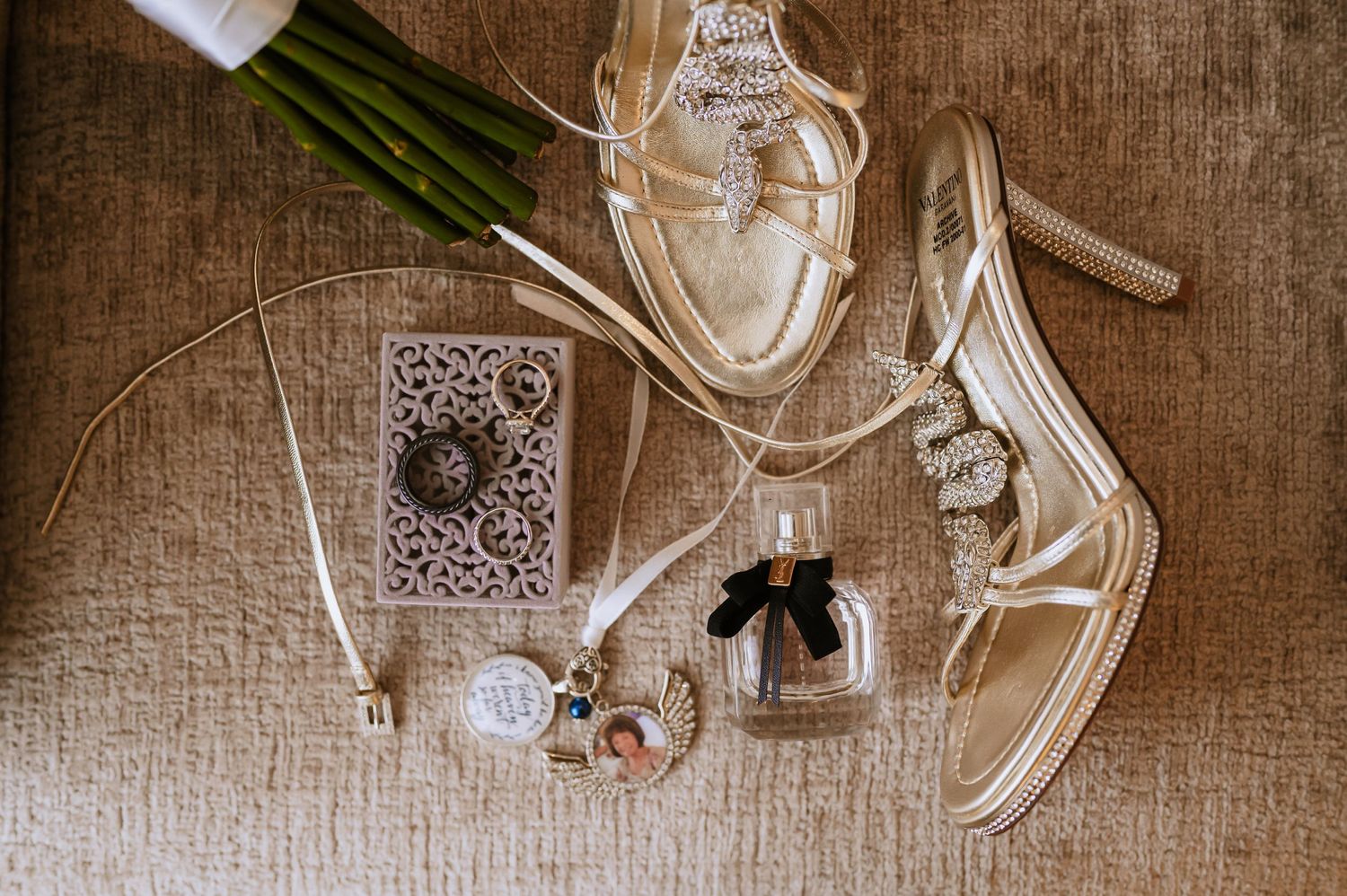 Wedding flat lay with white sandals, perfume bottle, and decorative accessories.