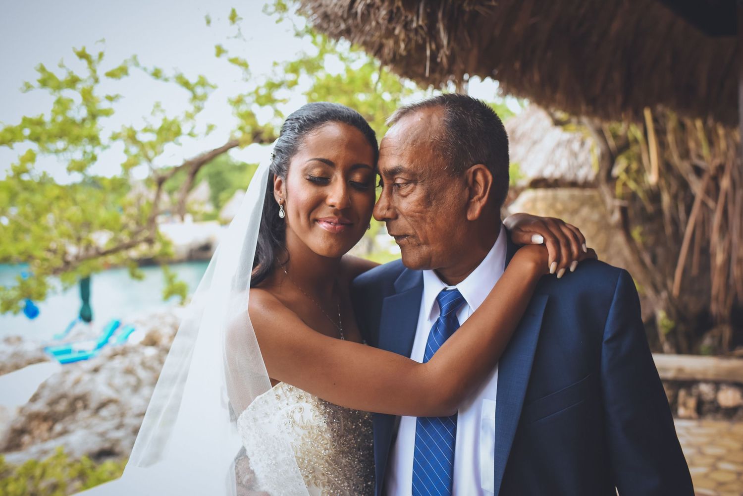 Candid wedding moments photographed at a beachfront location with natural scenery.