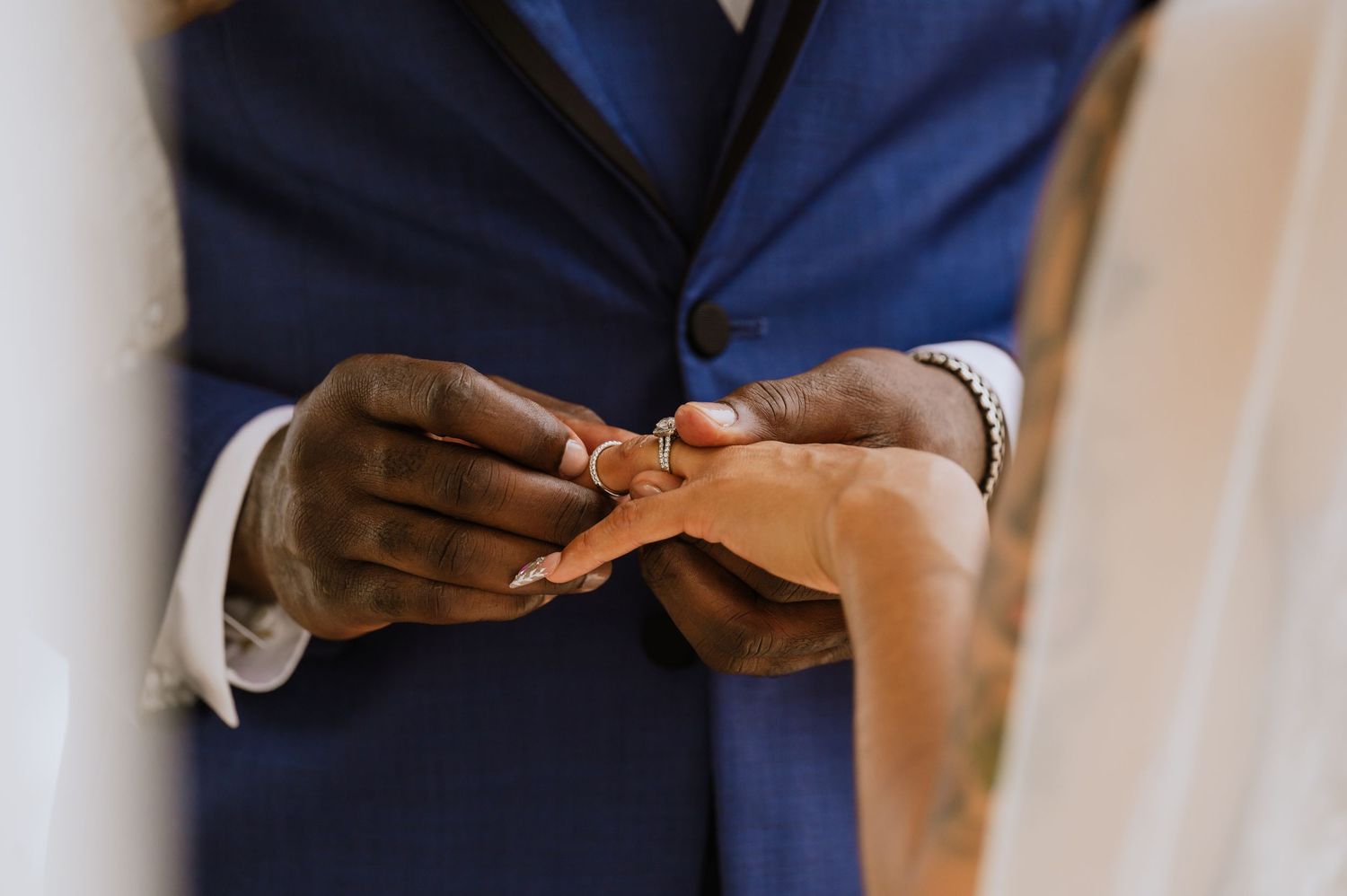 Close-up shot of hands exchanging wedding rings during a ceremony.