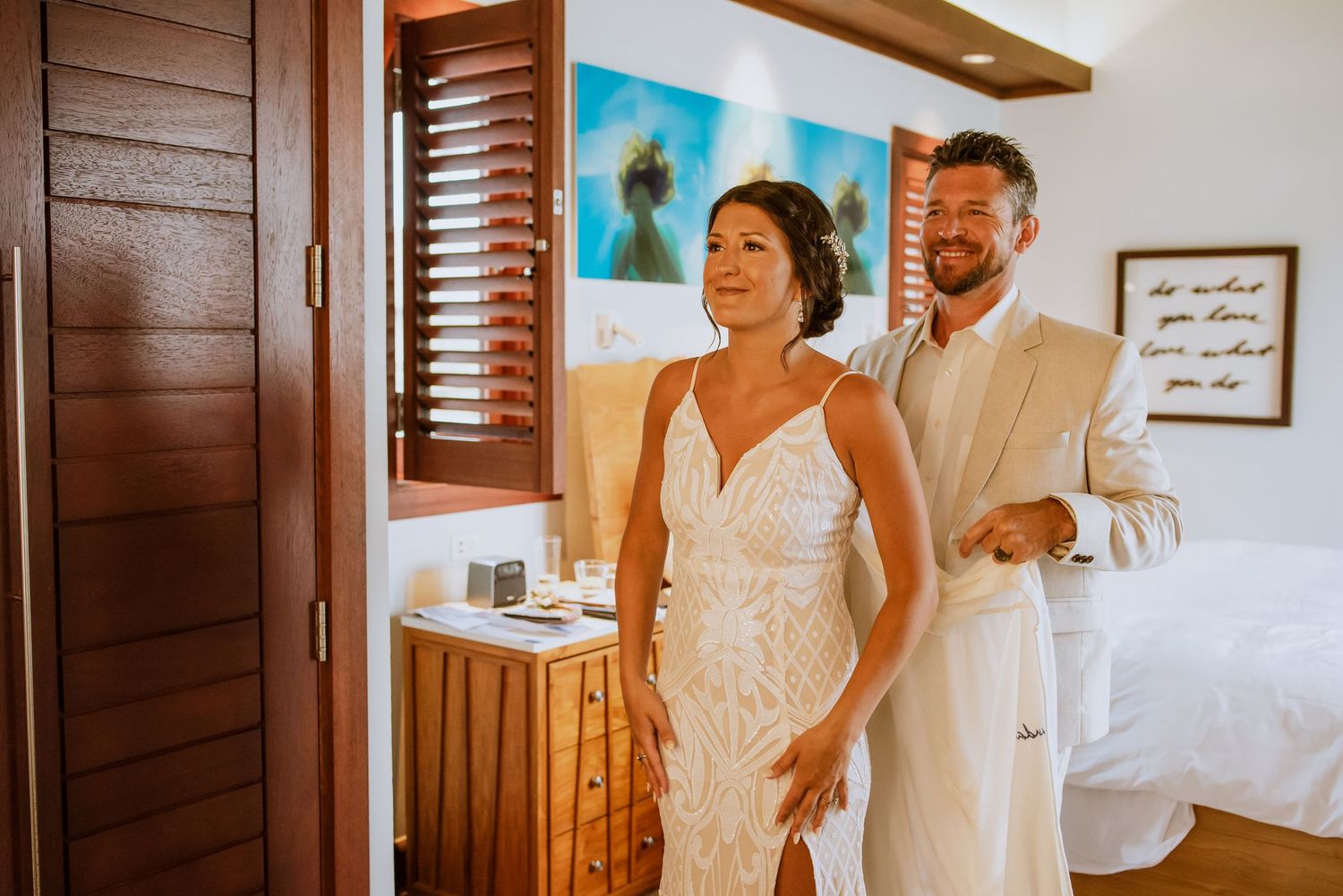 Intimate wedding getting-ready moment in a sun-filled room with coastal decor.
