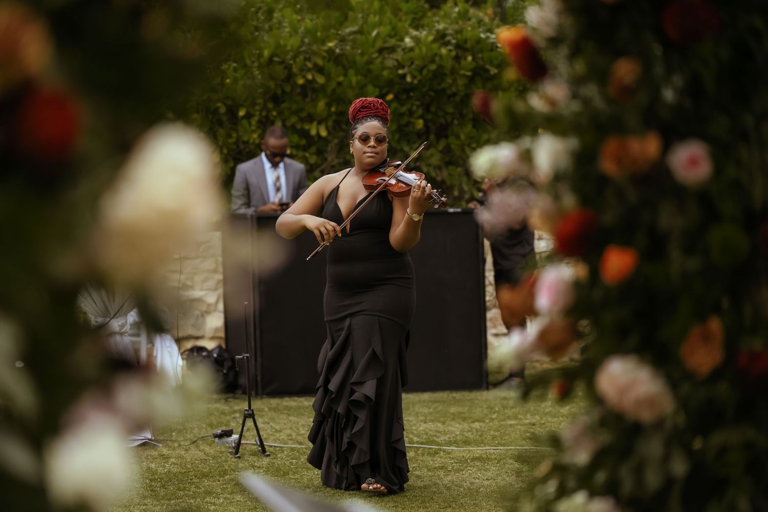 Outdoor wedding ceremony setup with floral decorations and natural garden backdrop.