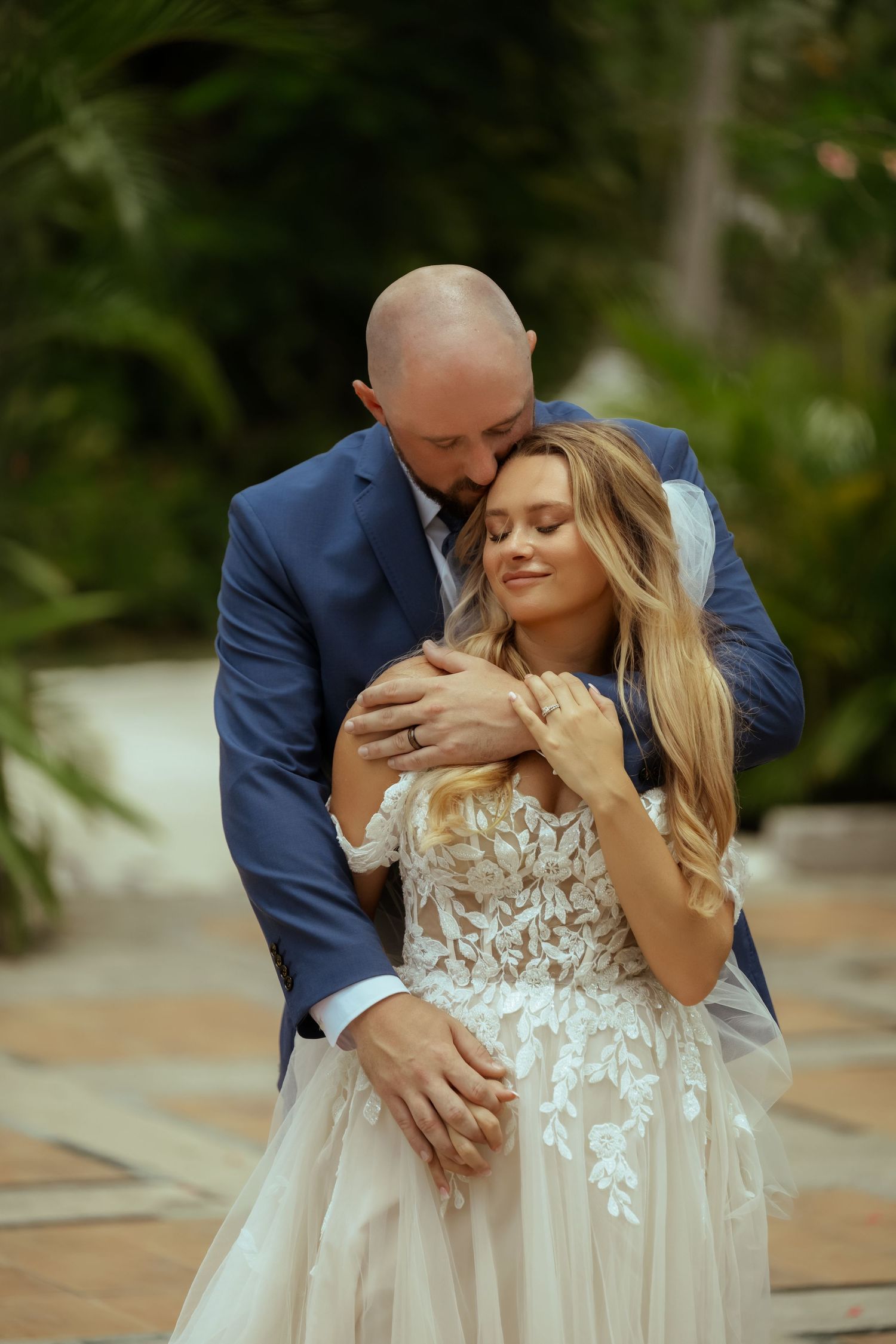 A romantic wedding couple shares intimate moments in a series of outdoor portraits against a natural backdrop.